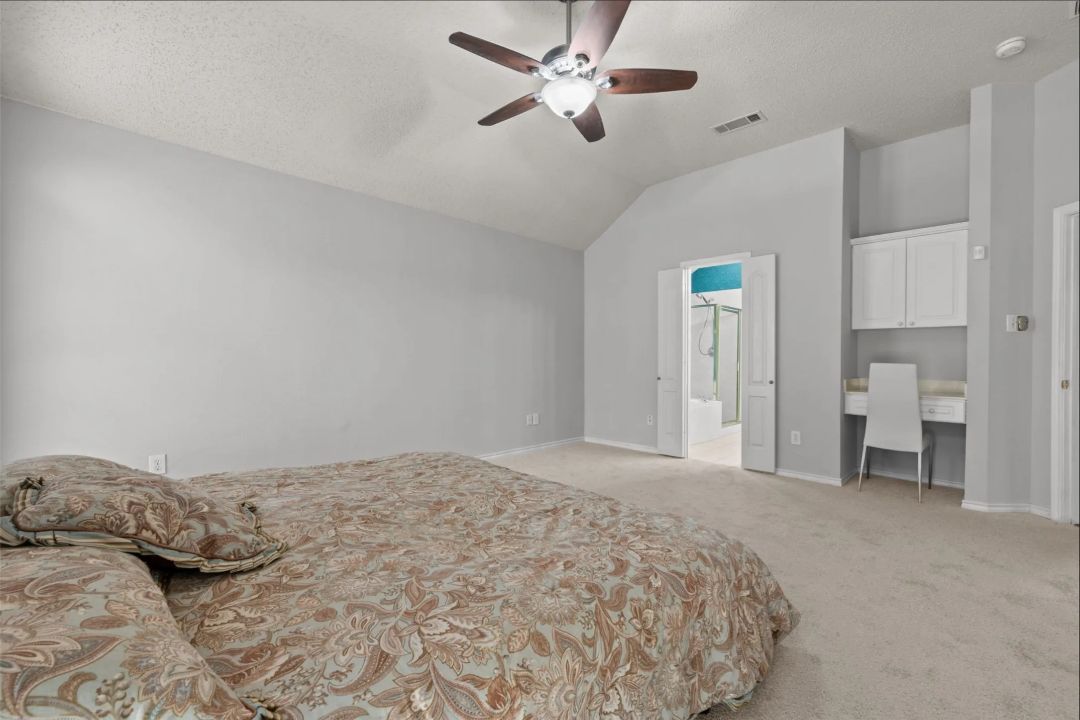 High ceiling, ceiling fan, integrated built-in desk, built-in vanity, and new carpet flooring