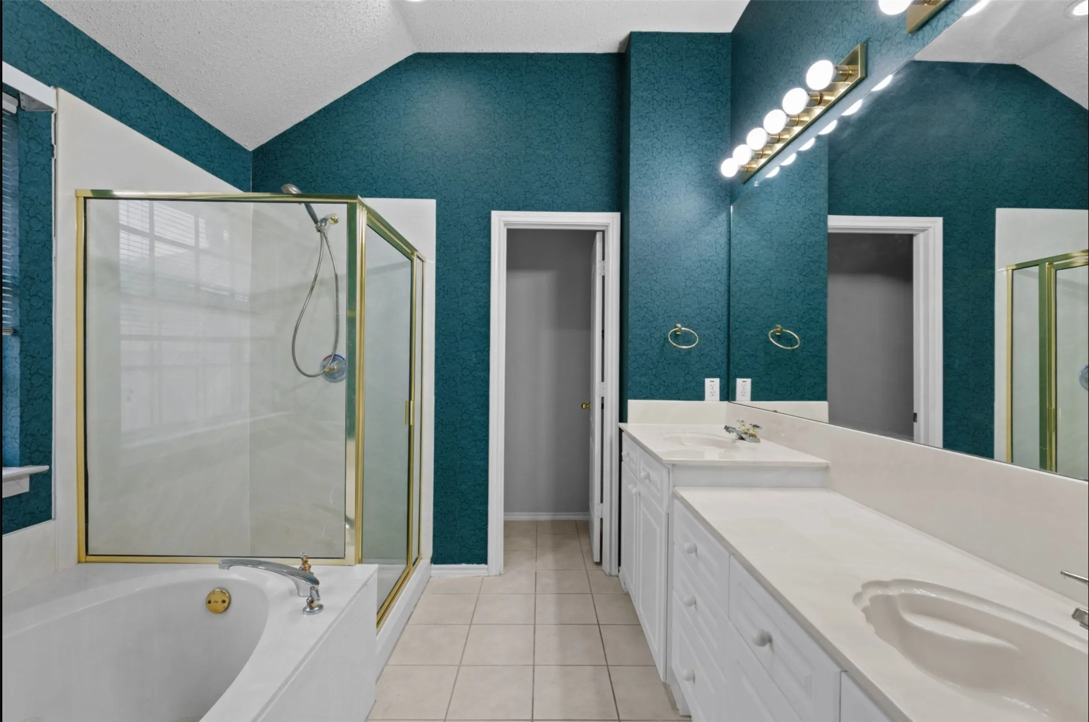 Dual vanity with integrated sinks, full-width mirror, and overhead lighting, jacuzzi soaker tub,