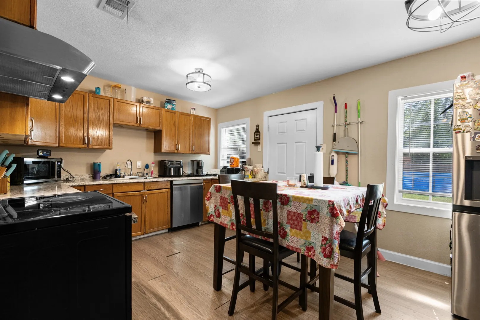Wood-finish flooring, wood cabinetry, stainless steel appliances, and a range hood