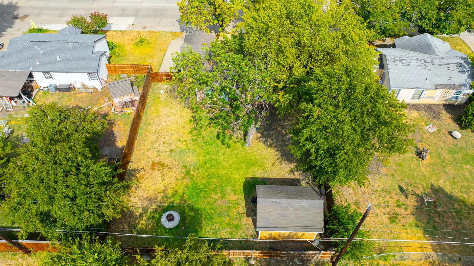 Expansive lot featuring mature trees and a wood-panel fence