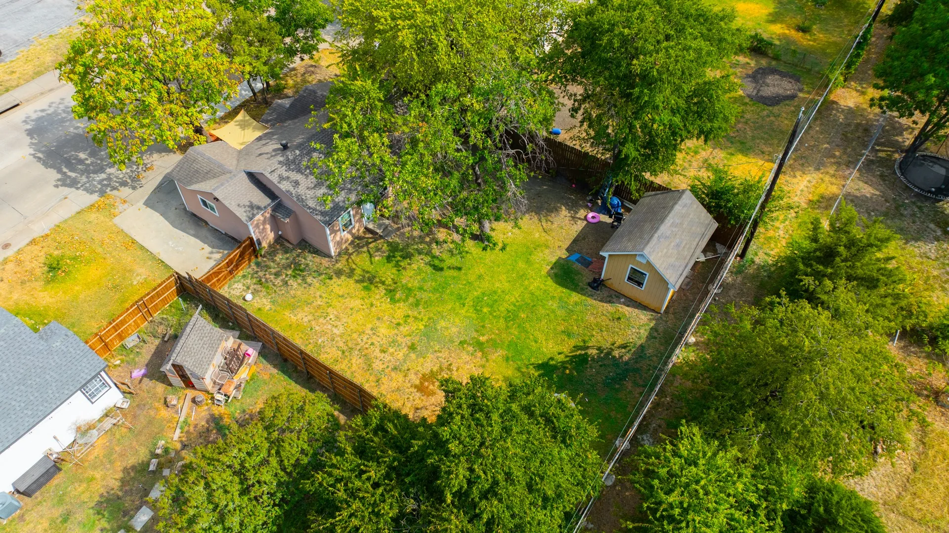 Expansive property featuring a detached shed, second detached shed, and a privacy fence