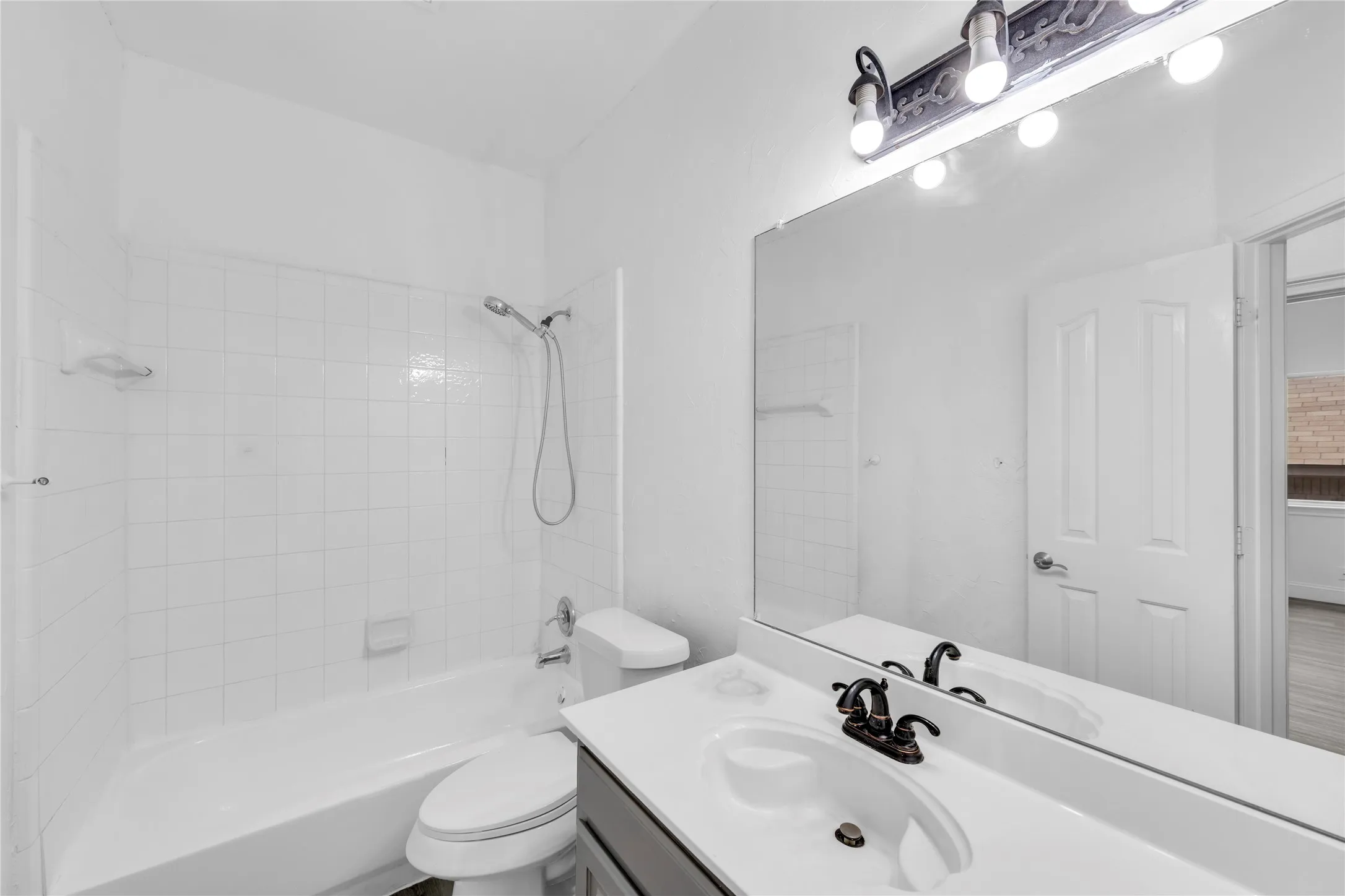 White-tiled bath and shower combination