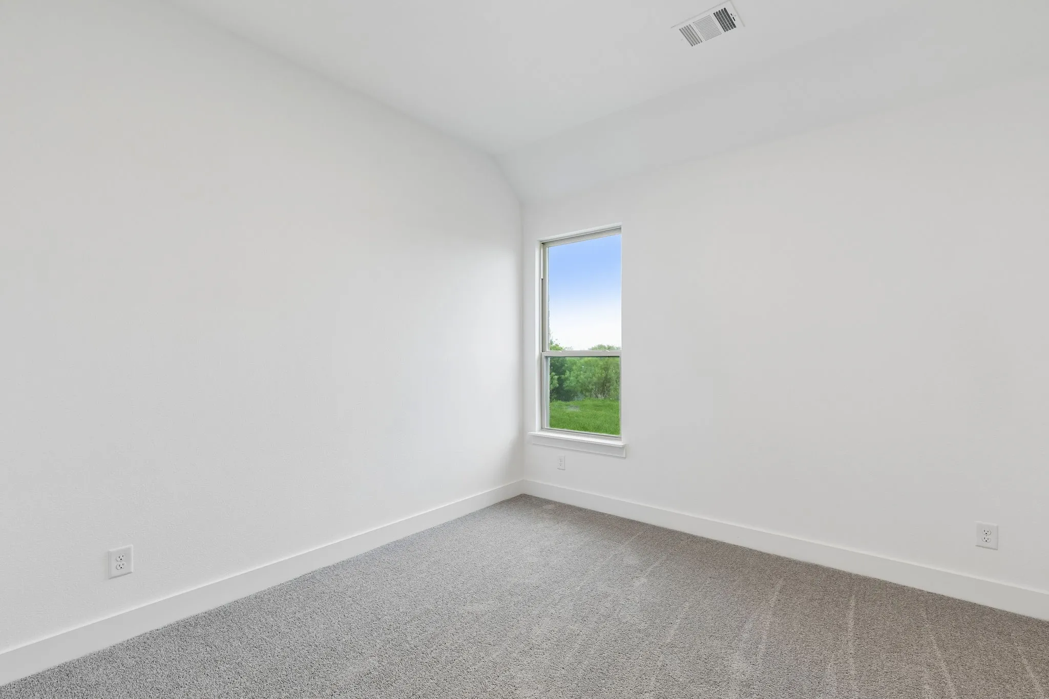 White wall finishes, gray carpet, and a single window with a white frame