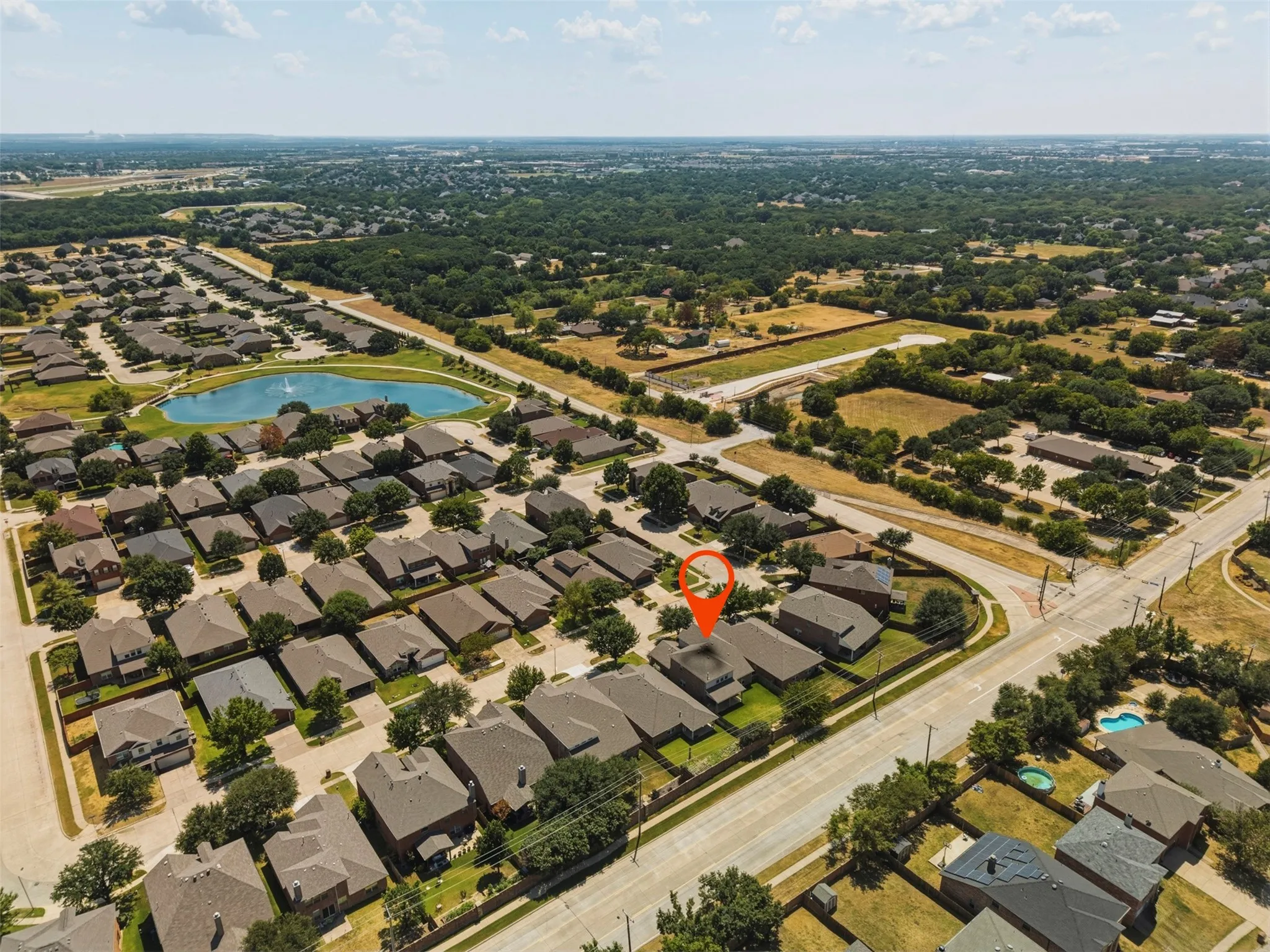 Residential neighborhood with established homes, mature trees, and a community pond