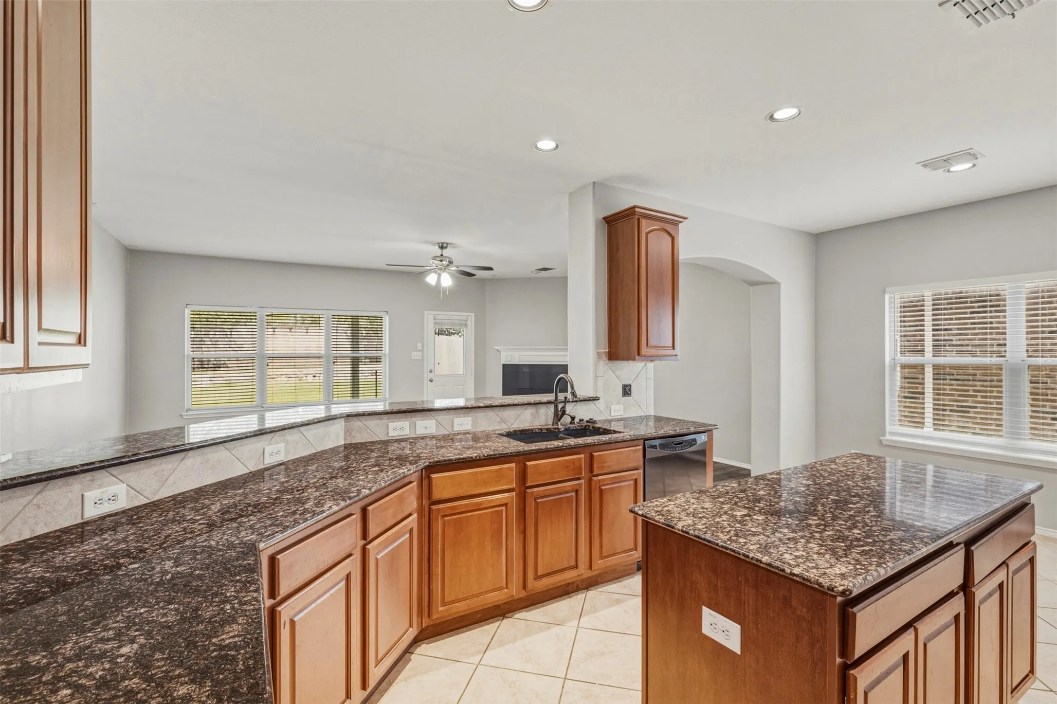 Kitchen featuring a central island, recessed lighting, and a window with blinds
