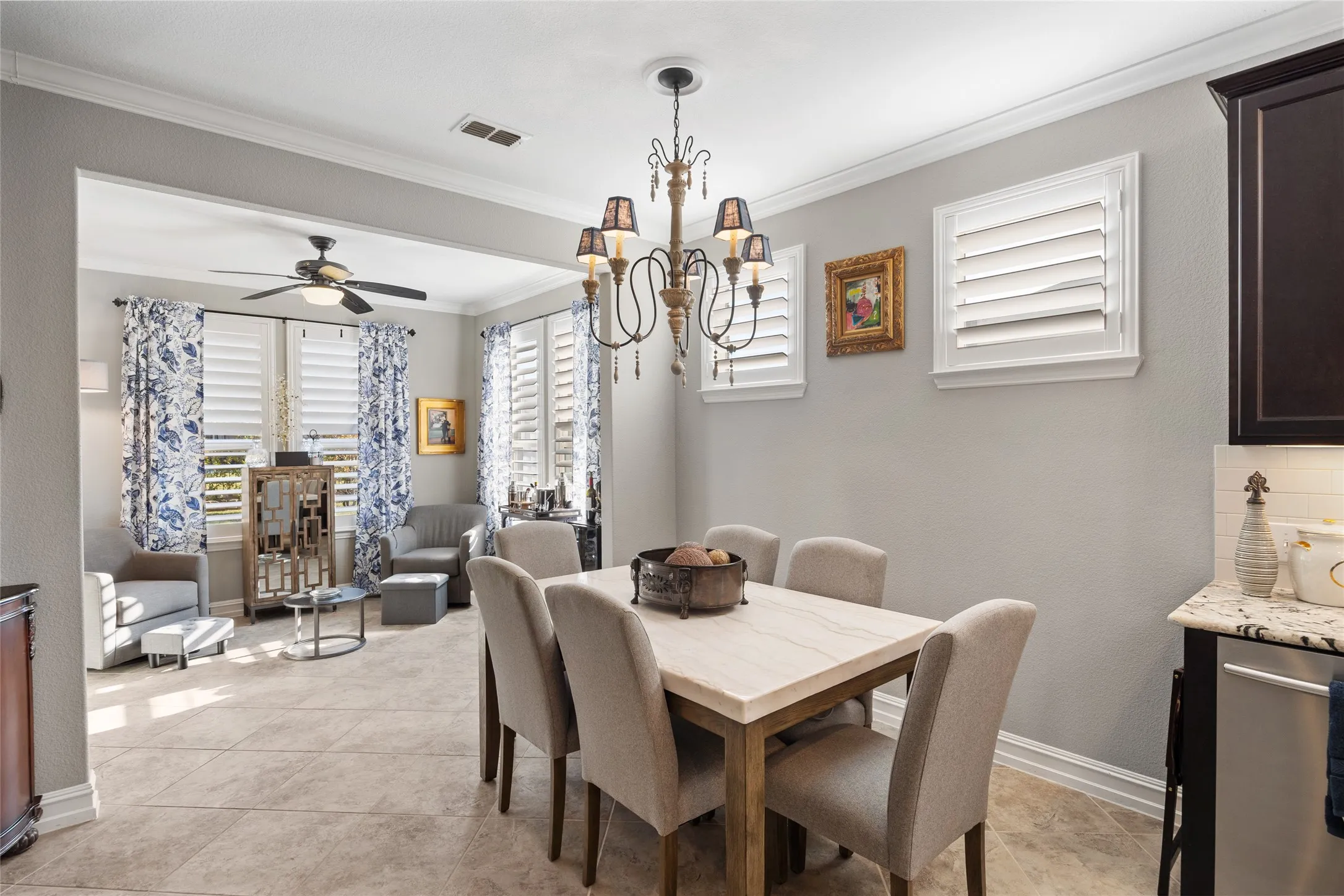 Dining area with chandelier, tile flooring, and crown molding