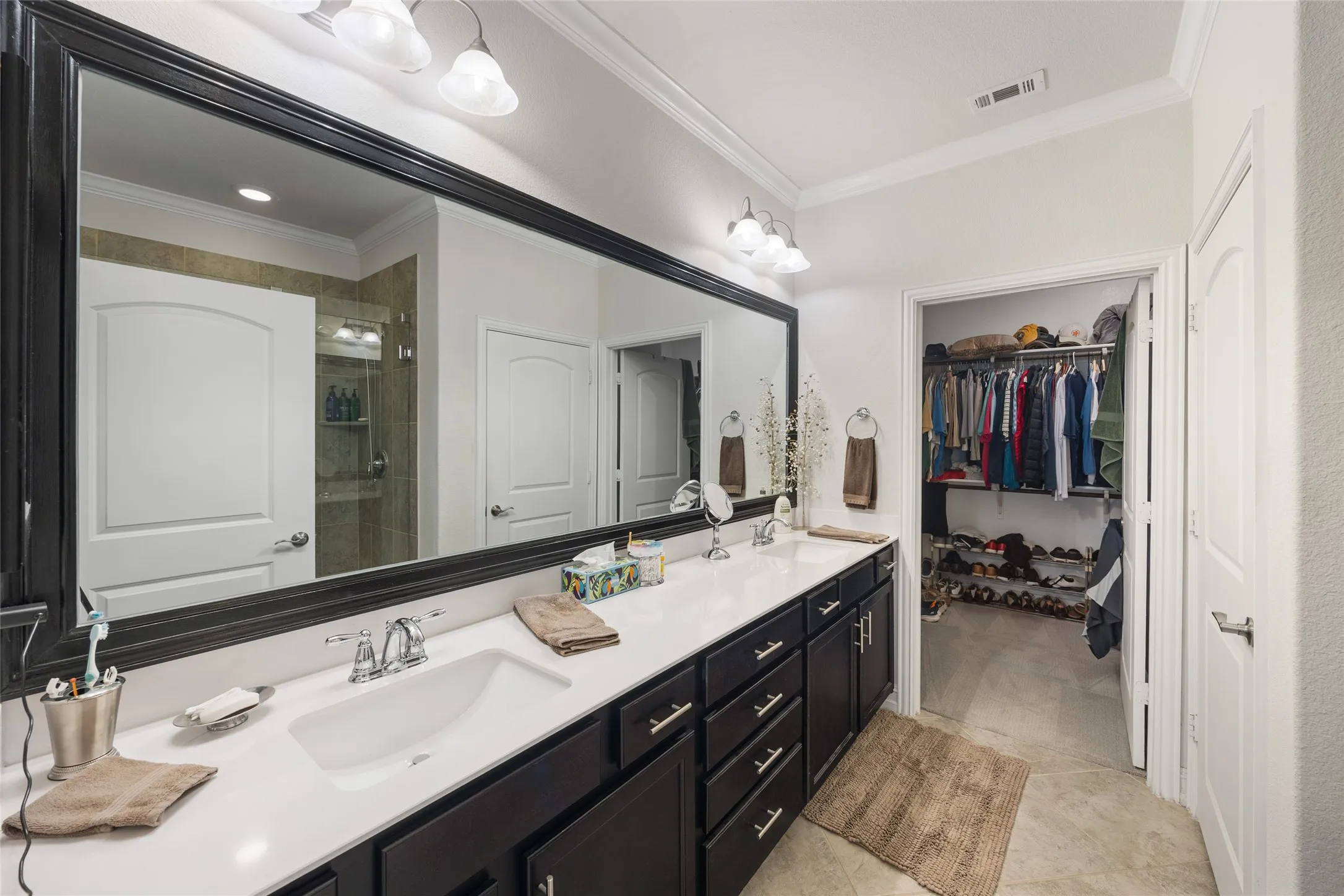 Double vanity with white countertop and dark wood-finish cabinetry