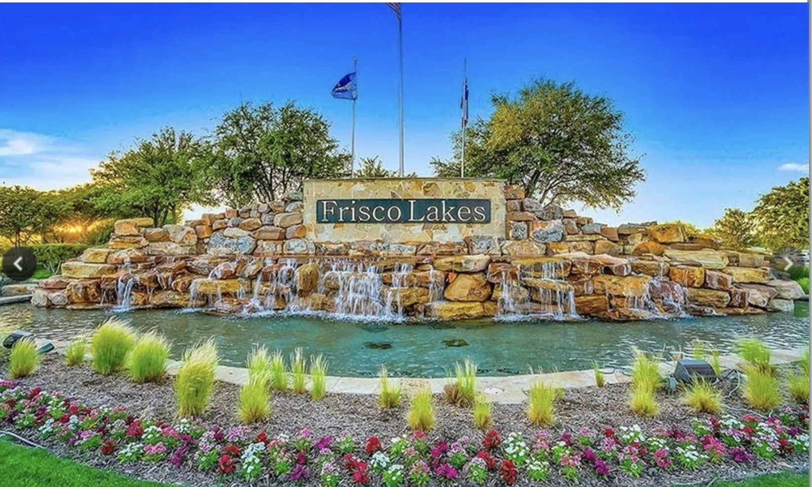Stone monument featuring a cascading waterfall, reflecting pool, and vibrant landscaping