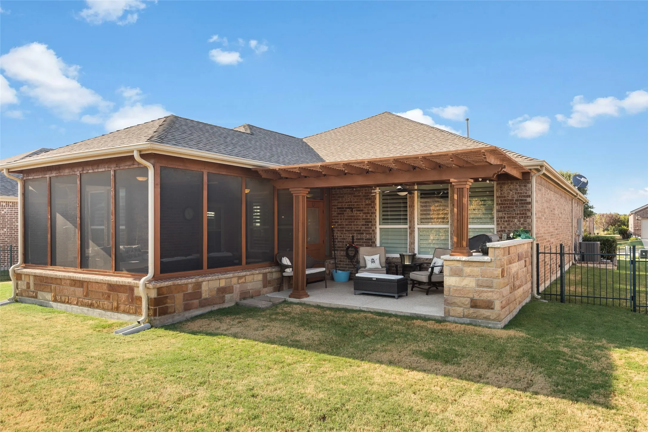 Screened-in porch with wood-frame construction and stone base