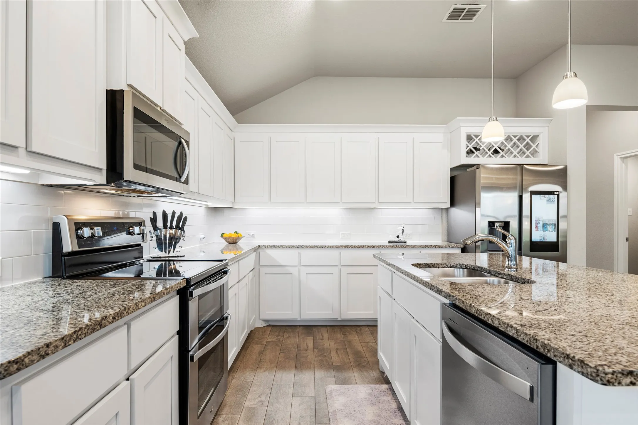 The subway tile backsplash and pendant lights add to the elegance of this home....