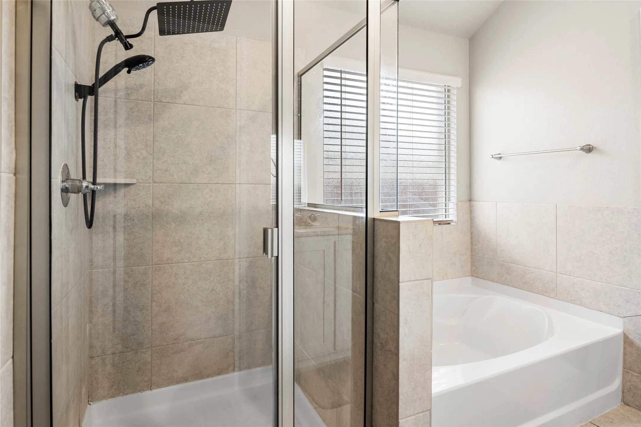 Enclosed glass shower with dark-finish fixtures and neutral tiled surround is a perfect blank slate for your decor.....