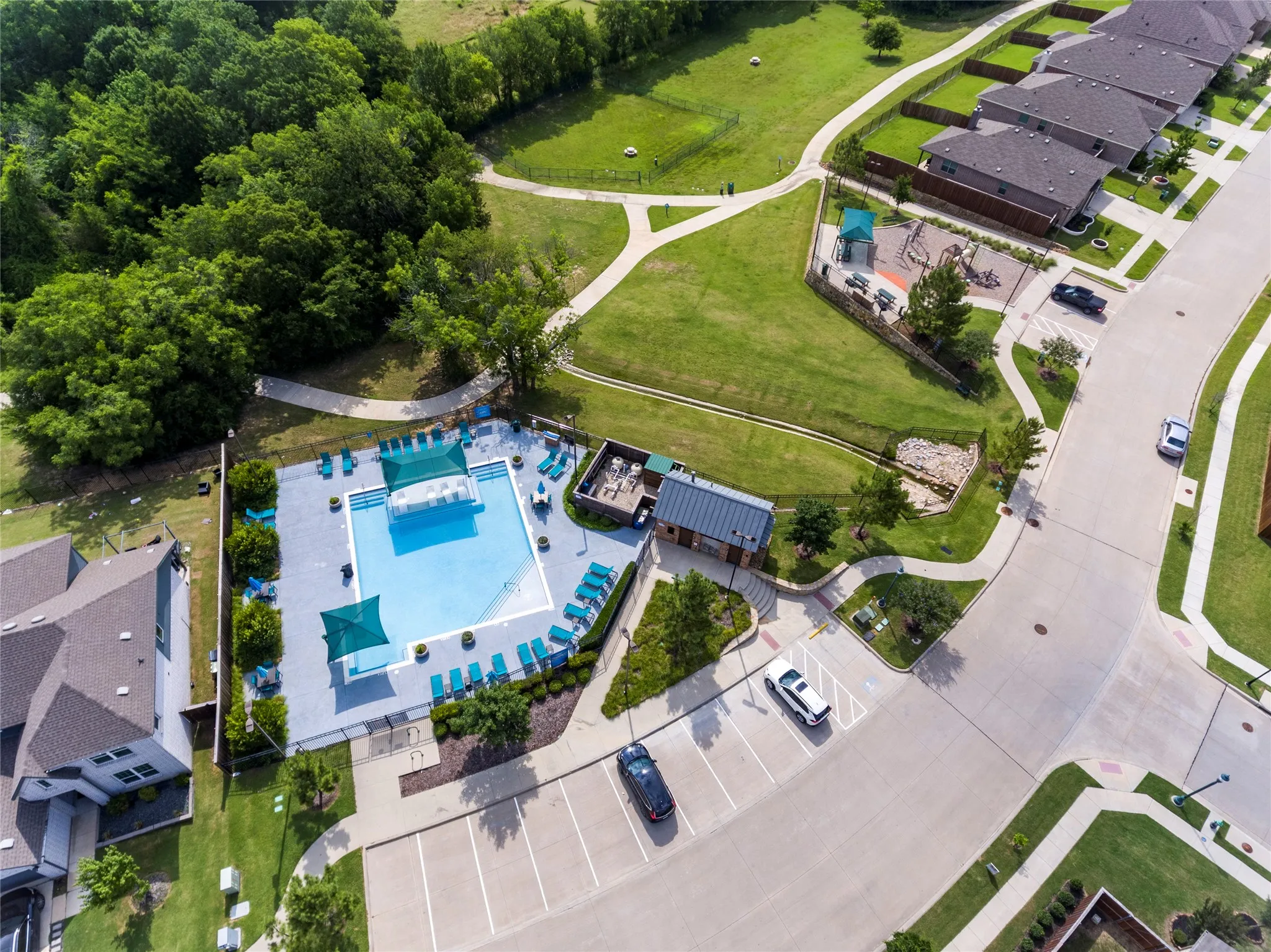 Stunning community amenities featuring a swimming pool, shaded lounge areas, adjacent club house, nearby playground, and walking paths.....don't you just love those mature trees????