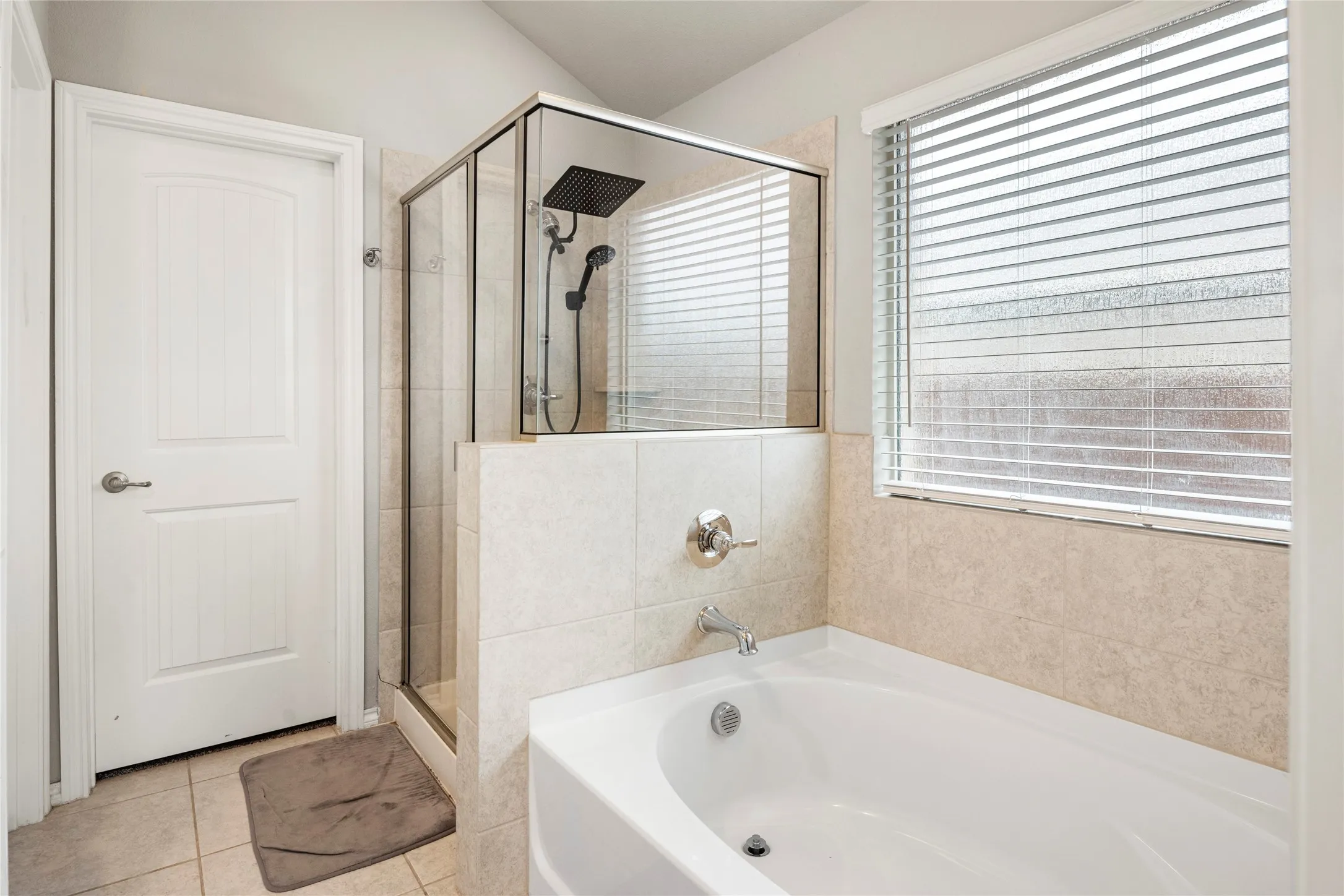 Glass-enclosed shower with a rain shower head and a separate soaking tub is any girl's dream....
