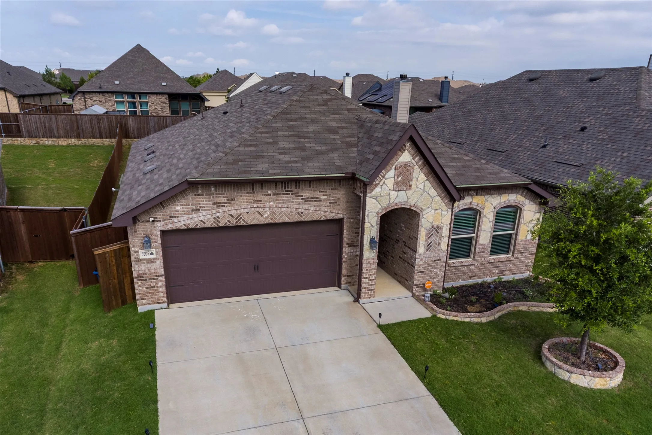 Brick and stone facade with beautiful arched entryway, two-car garage, windows and well kept concrete driveway, and a fenced backyard.....great home for your family!!