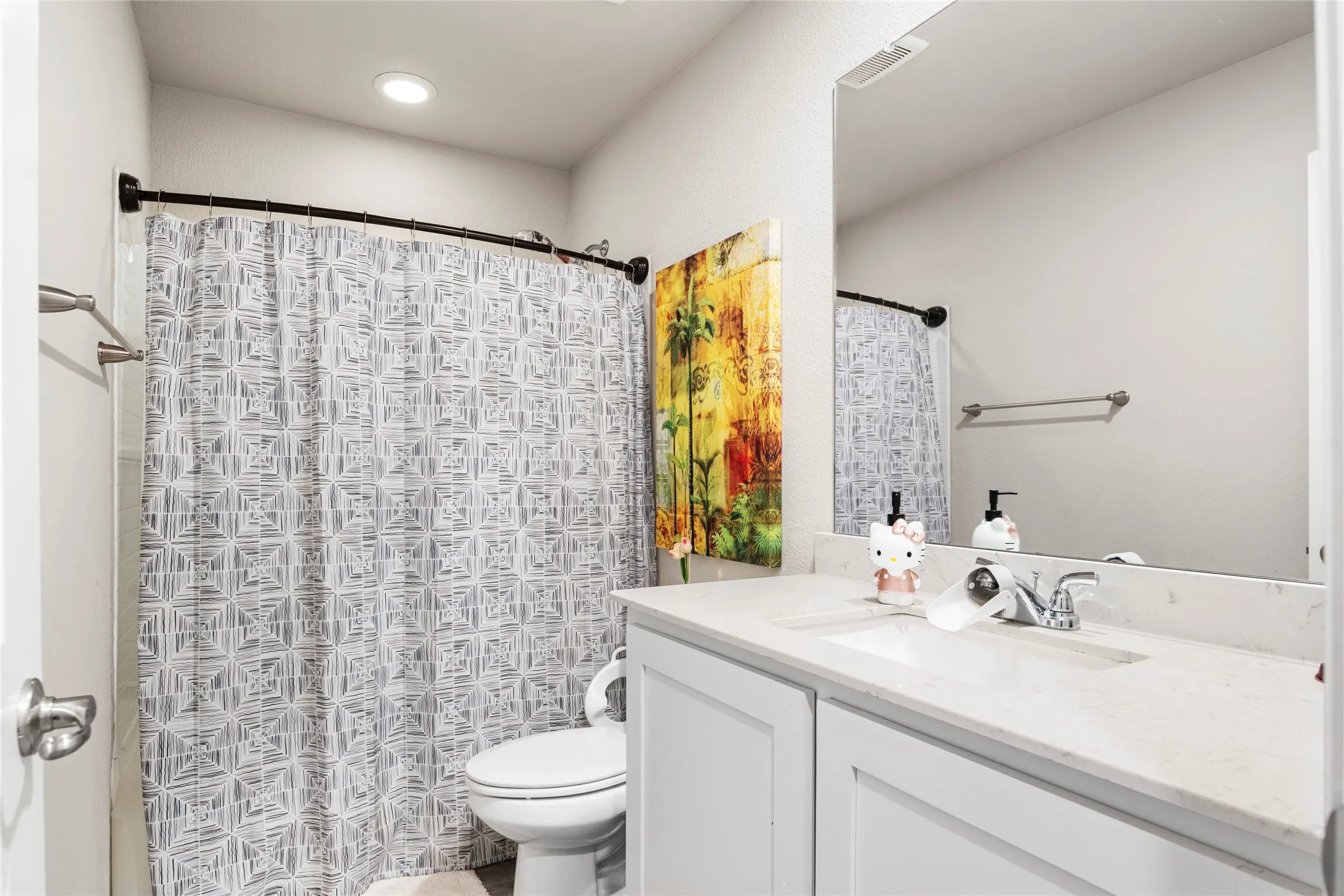 Vanity with an integrated sink, polished chrome faucet, and wide wall-mounted mirror