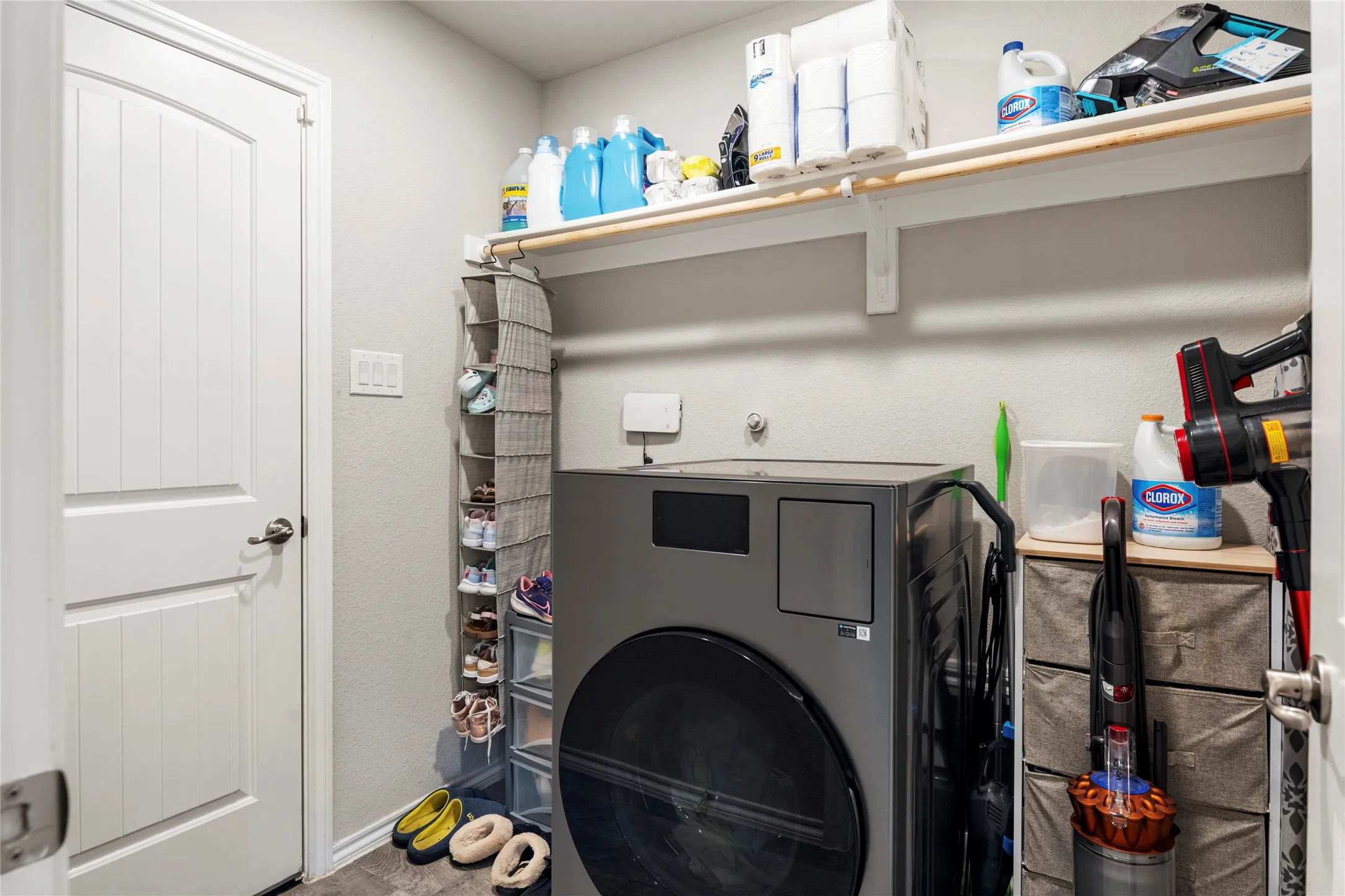 Laundry area featuring a built-in shelf and clothes rod and access to the garage....