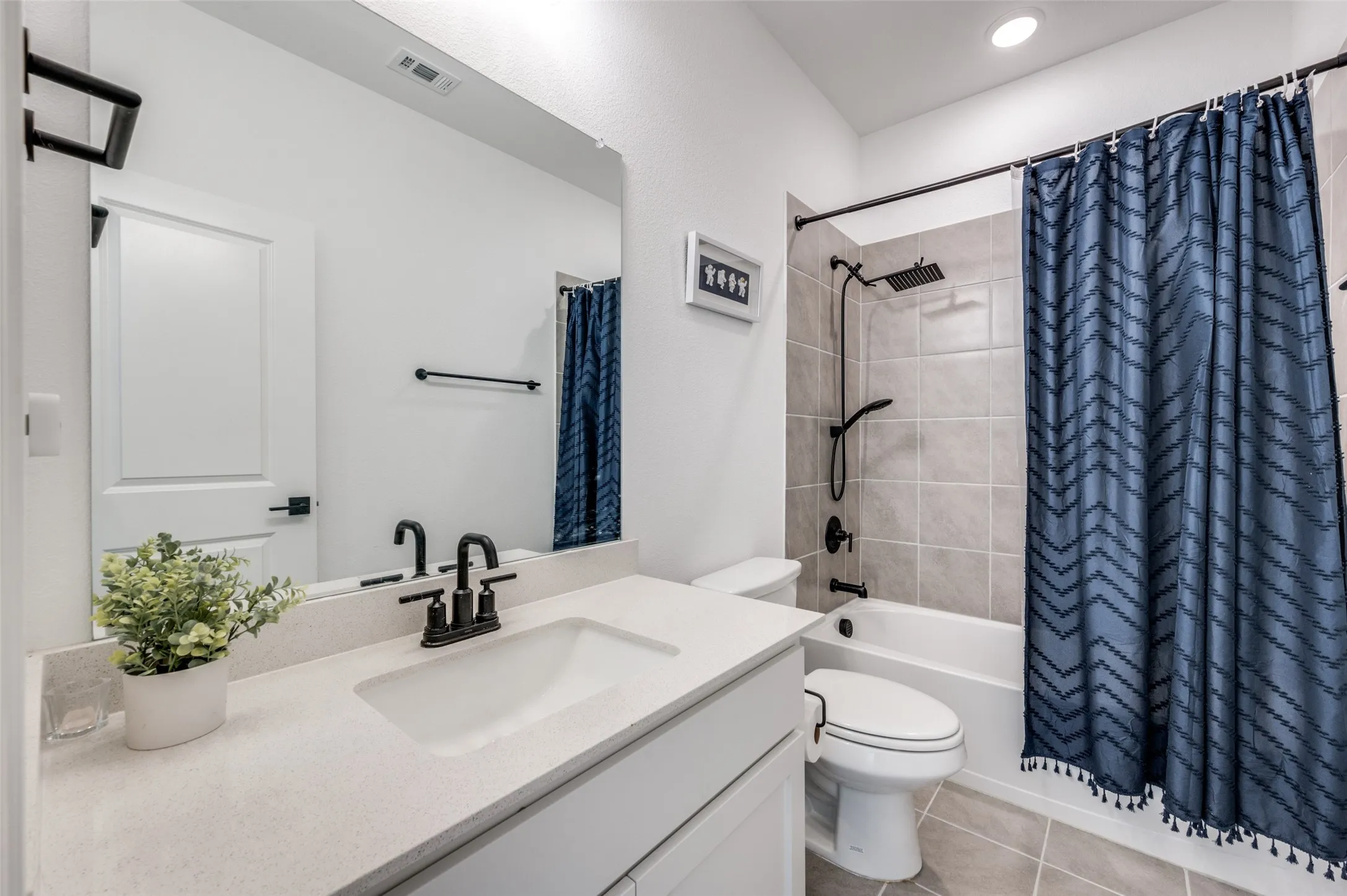 White vanity with a light-toned countertop, rectangular undermount sink, and matte black faucet