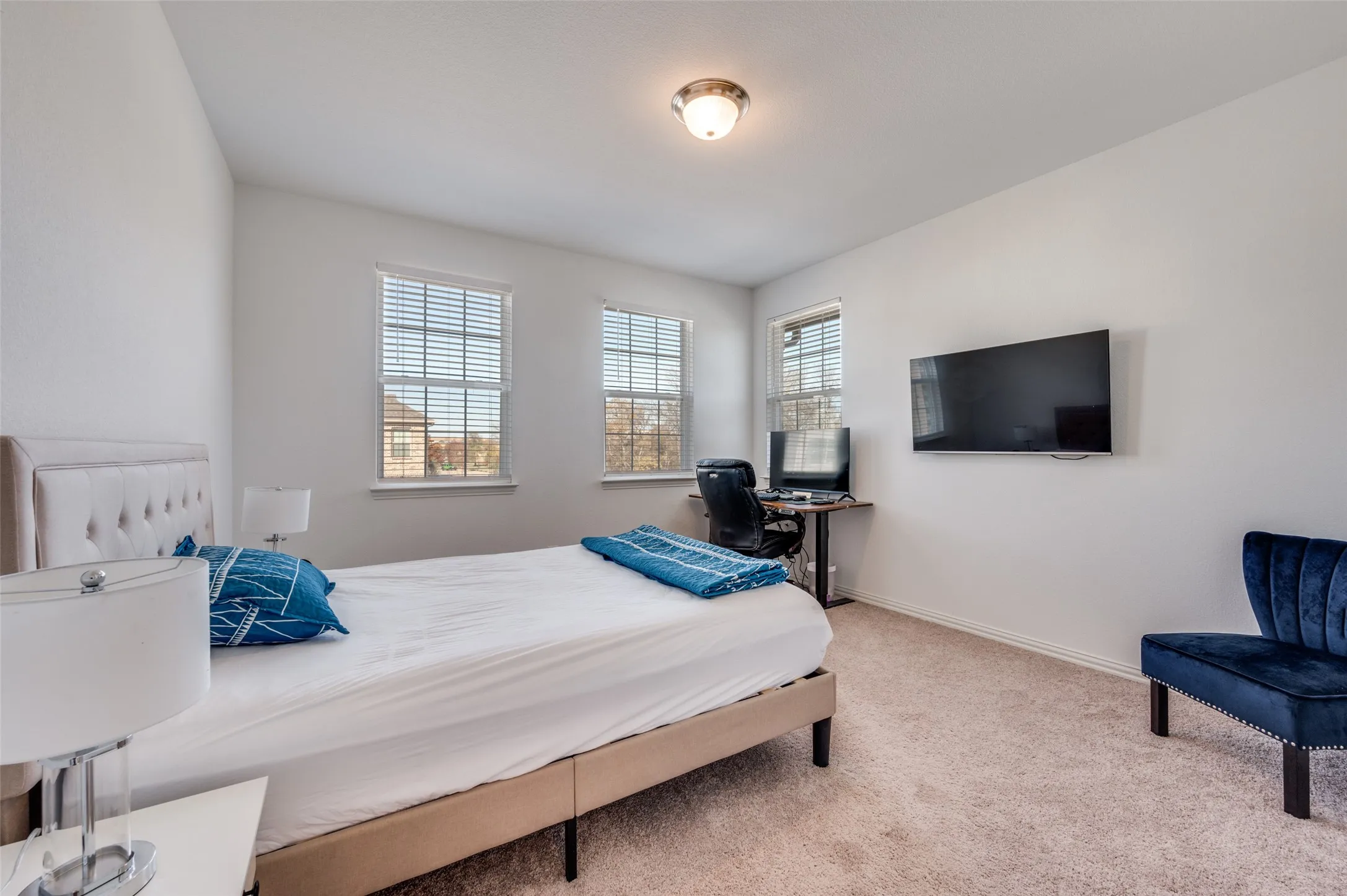Recessed lighting, light-colored carpeting, and three windows with blinds