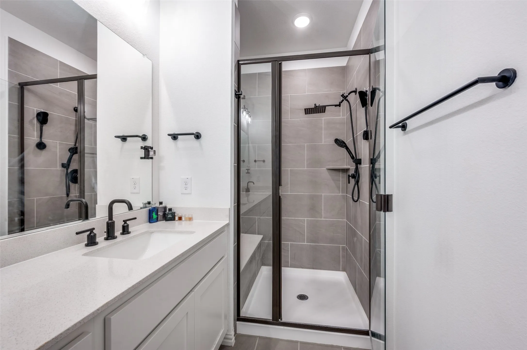 White vanity with a solid surface countertop, undermount sink, and matte black fixtures