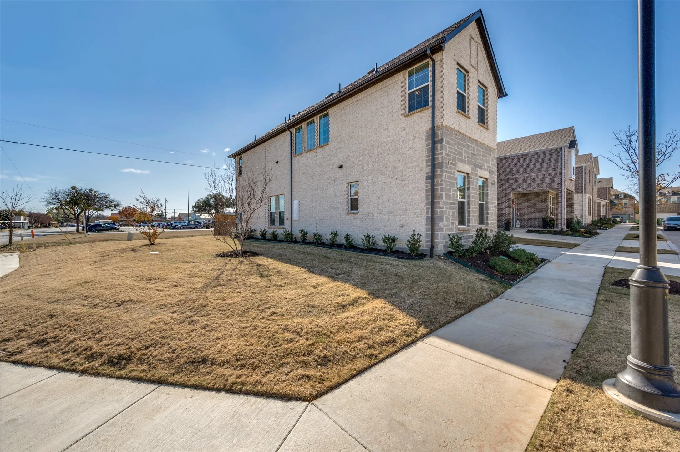 Two-story exterior with brick and stone accents, featuring multiple windows, and a landscaped foundation planting