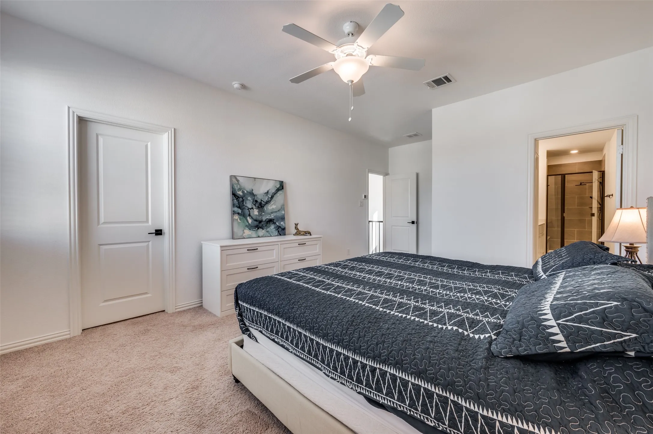 Neutral tone wall paint with a ceiling fan light fixture and carpet flooring