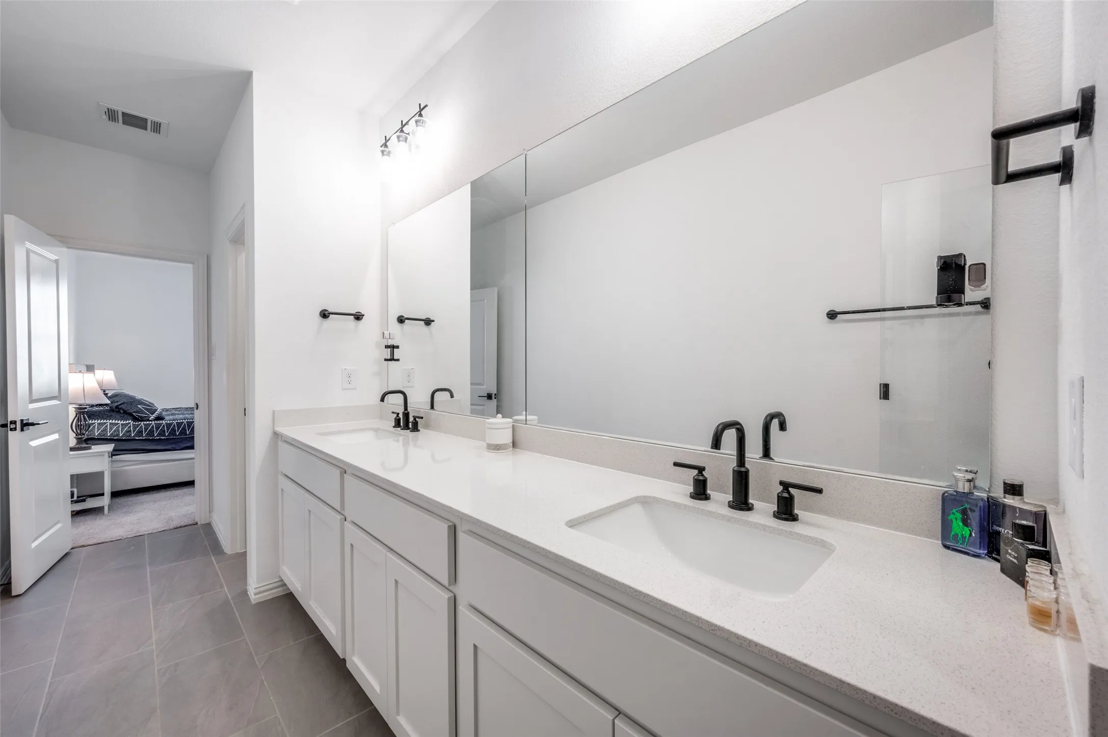 Dual vanity with integrated sinks, white cabinetry, and matte black fixtures