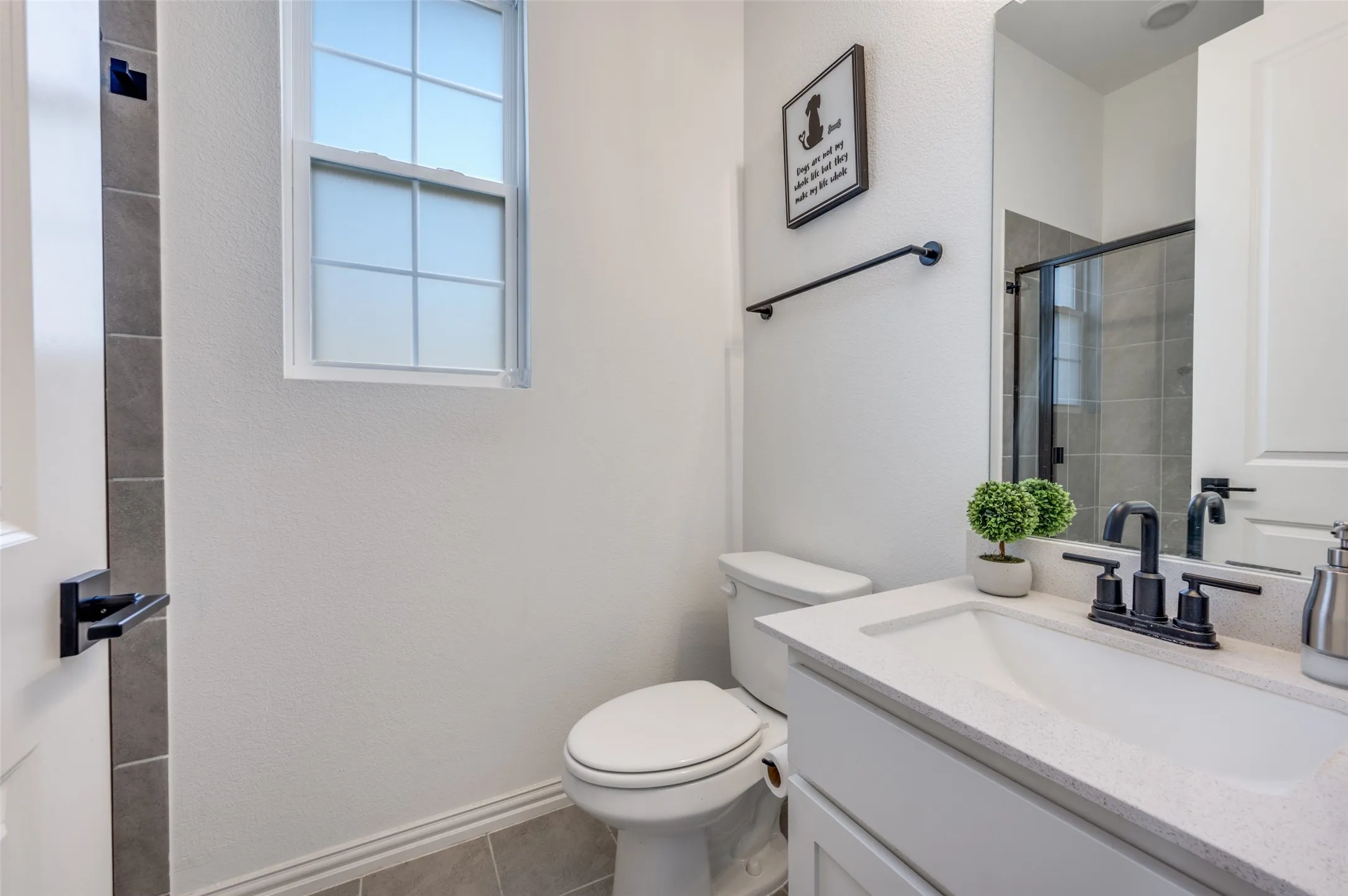 White vanity with a light-colored countertop, undermount sink, and matte black faucet