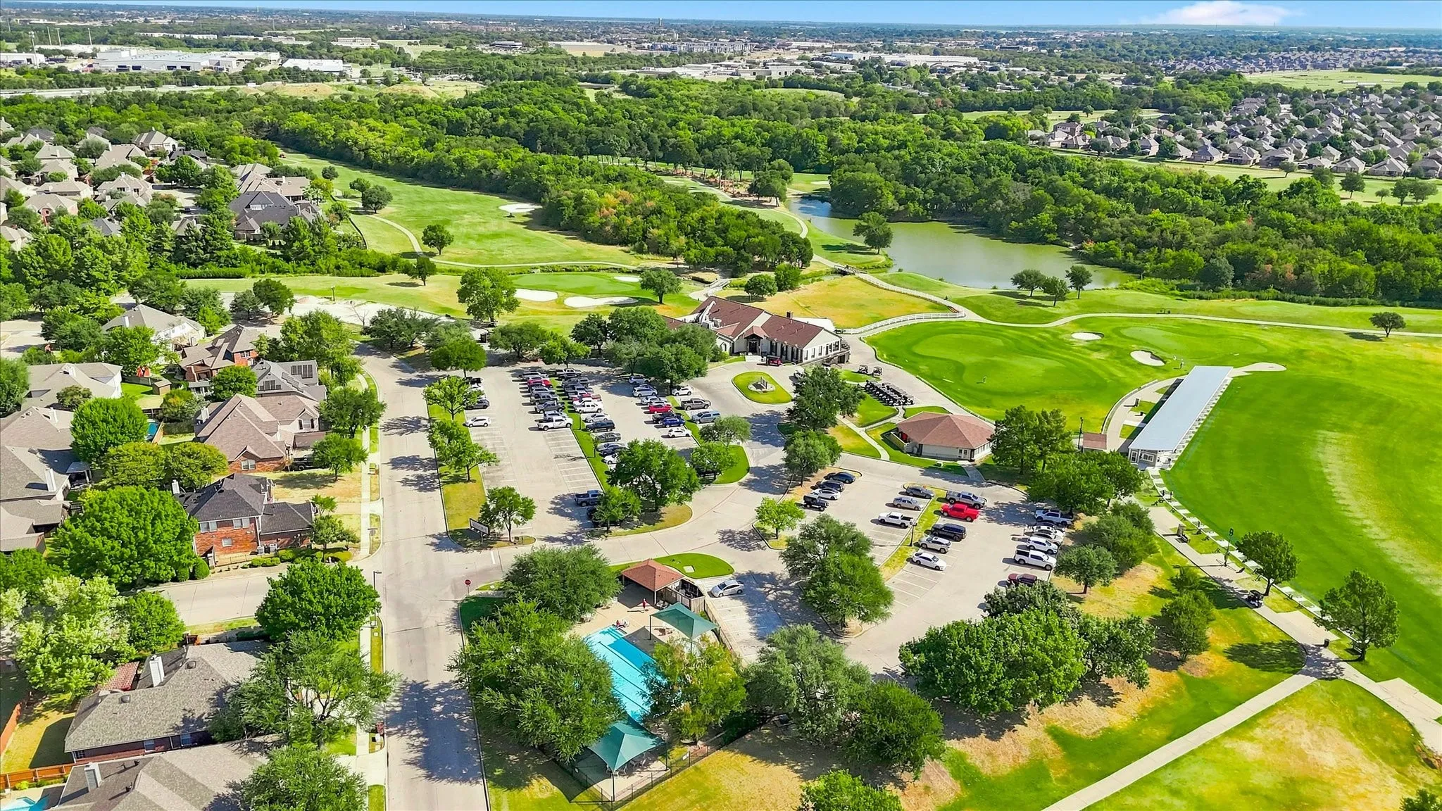 View of the clubhouse, a pool and the golf course
