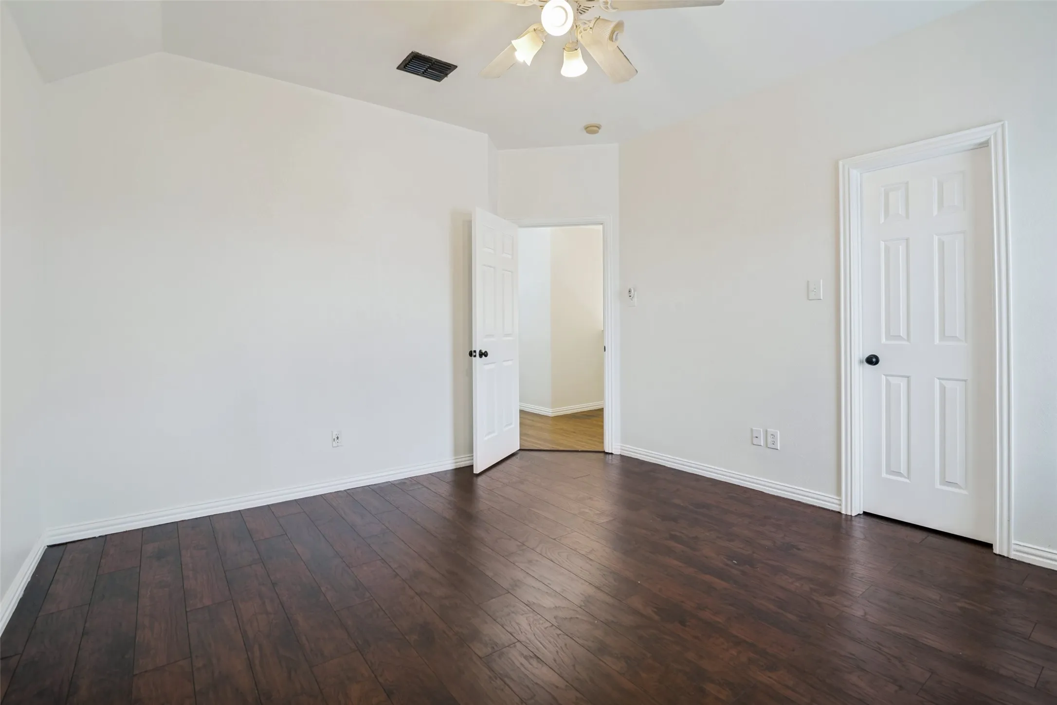 Upstairs gamroom. Wood-finish flooring, white walls, and a ceiling fan with light fixture