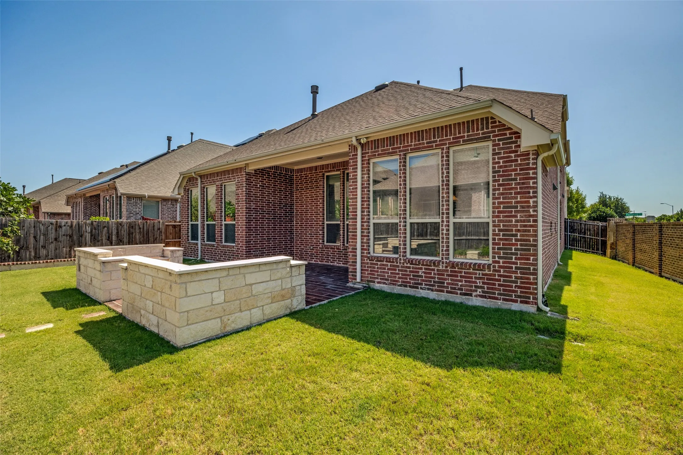 Brick exterior, large backyard, stone retaining walls, covered patio, multiple windows