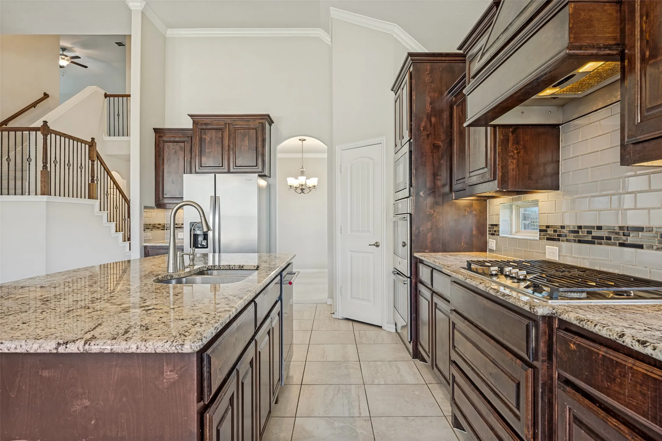Kitchen featuring granite countertops, wood cabinetry, stainless steel appliances, and a gas cooktop