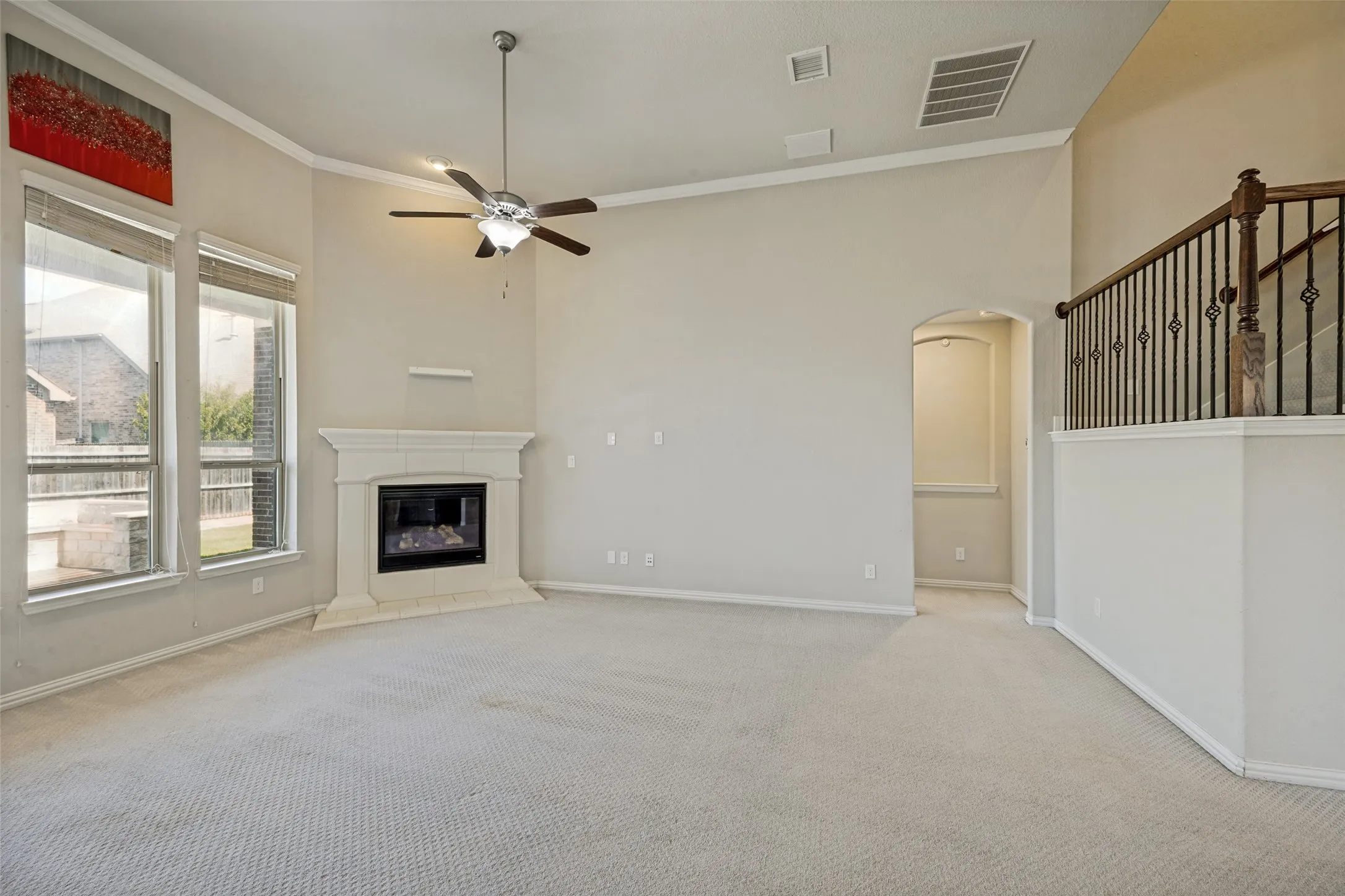 Spacious room featuring vaulted ceilings, a corner fireplace, and large windows