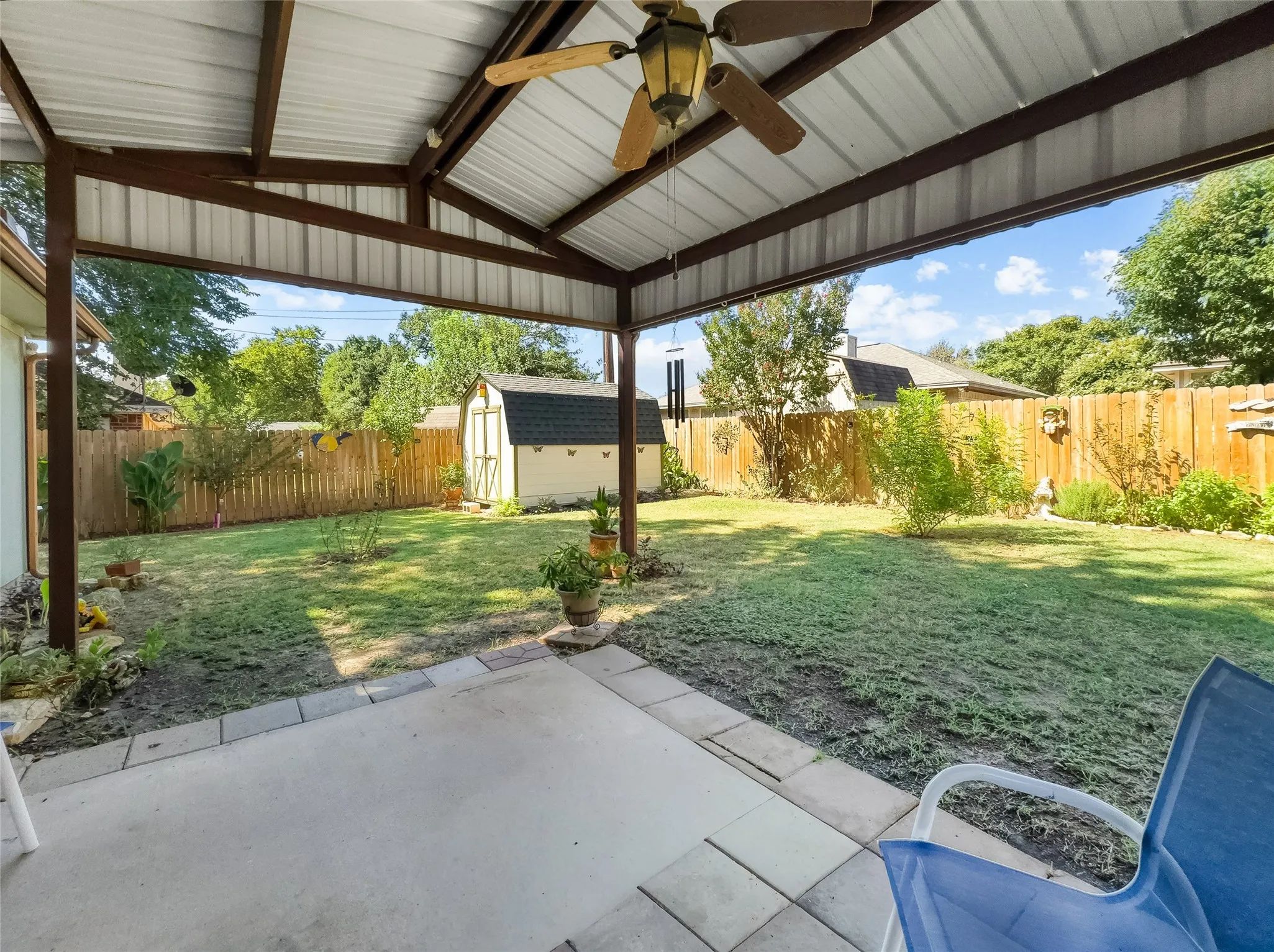 Covered patio with a ceiling fan, concrete paver flooring, and a fenced backyard