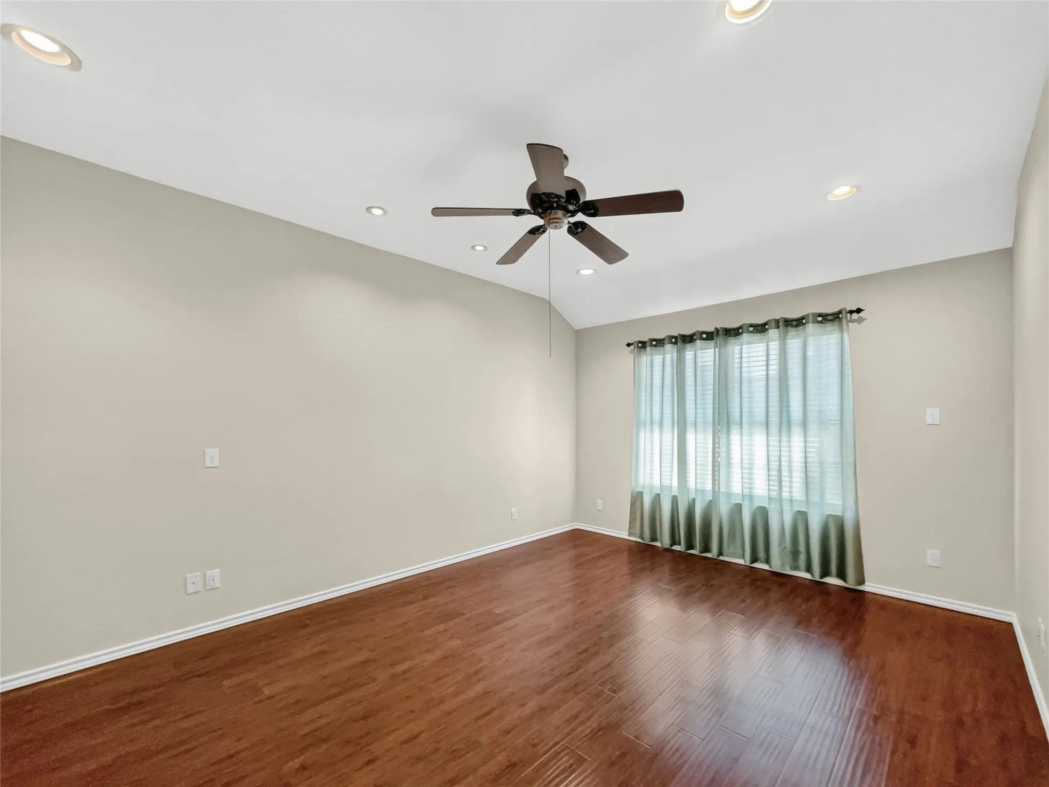 Wood-finish flooring with neutral wall tones, recessed lighting, and a ceiling fan