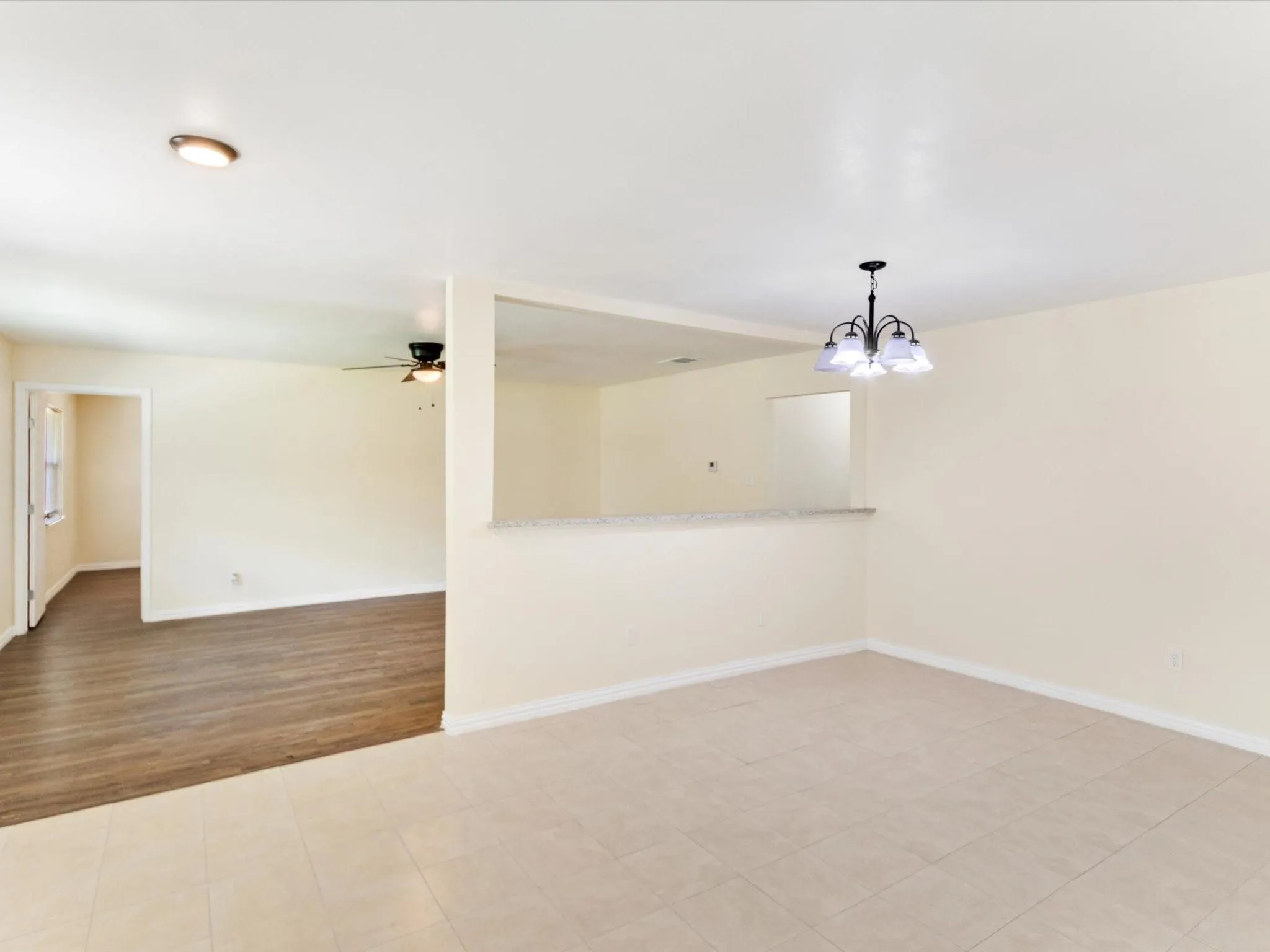 Ceramic tile flooring, wood-finish flooring, recessed lighting, ceiling fan, and a chandelier