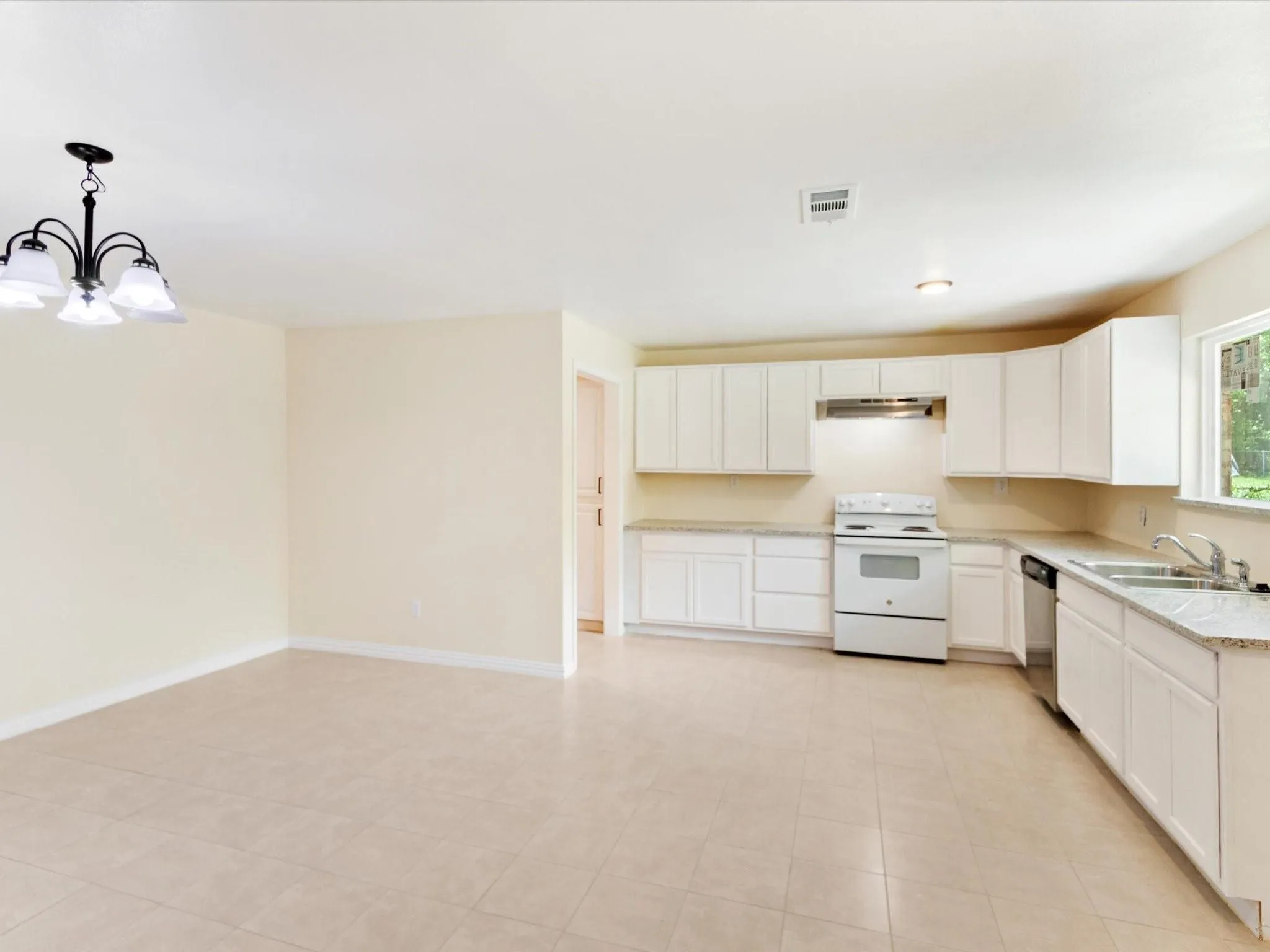 Kitchen featuring white cabinetry, light-toned countertops, a stainless steel sink, and a white electric range