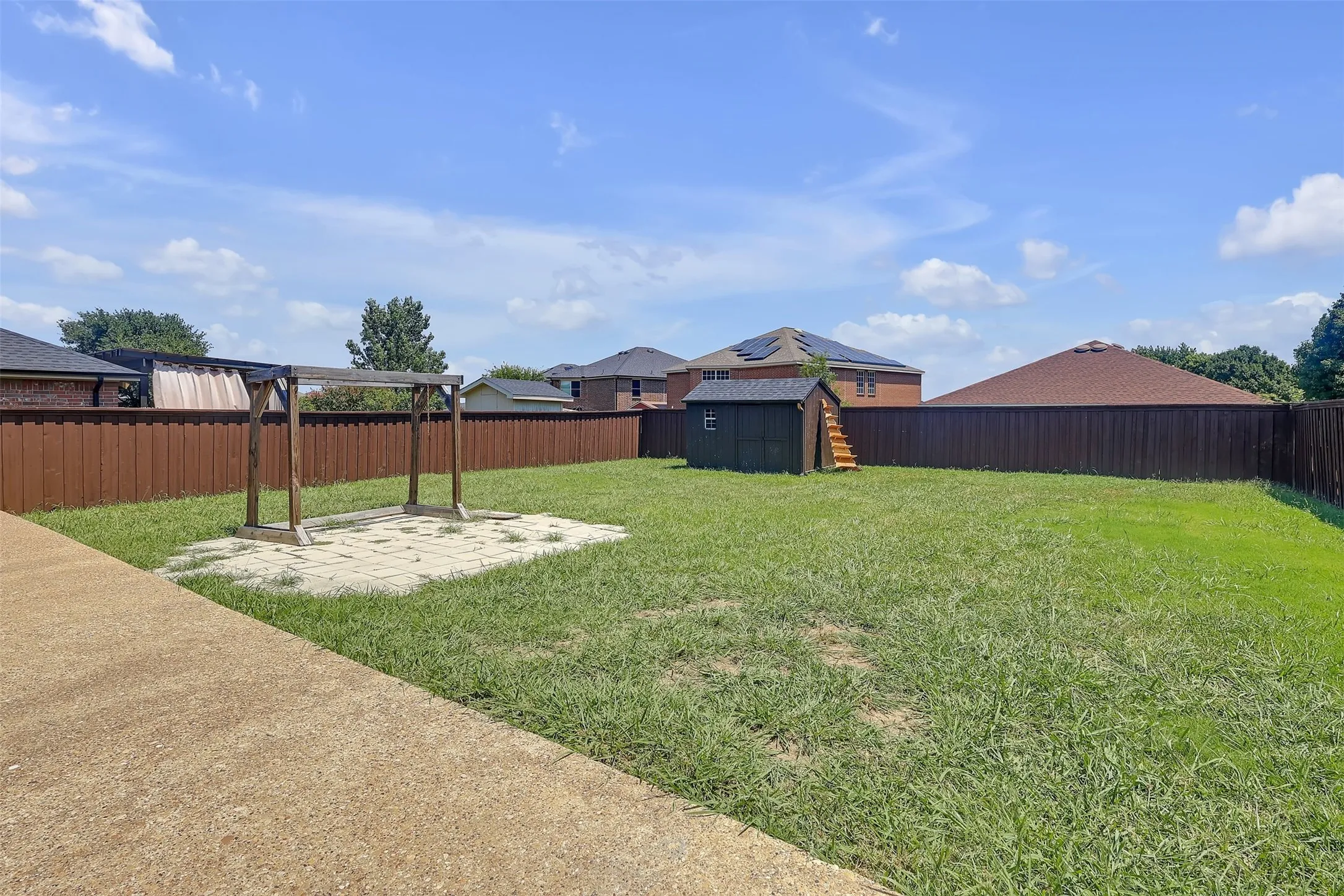 Fenced backyard with a patio and a storage shed