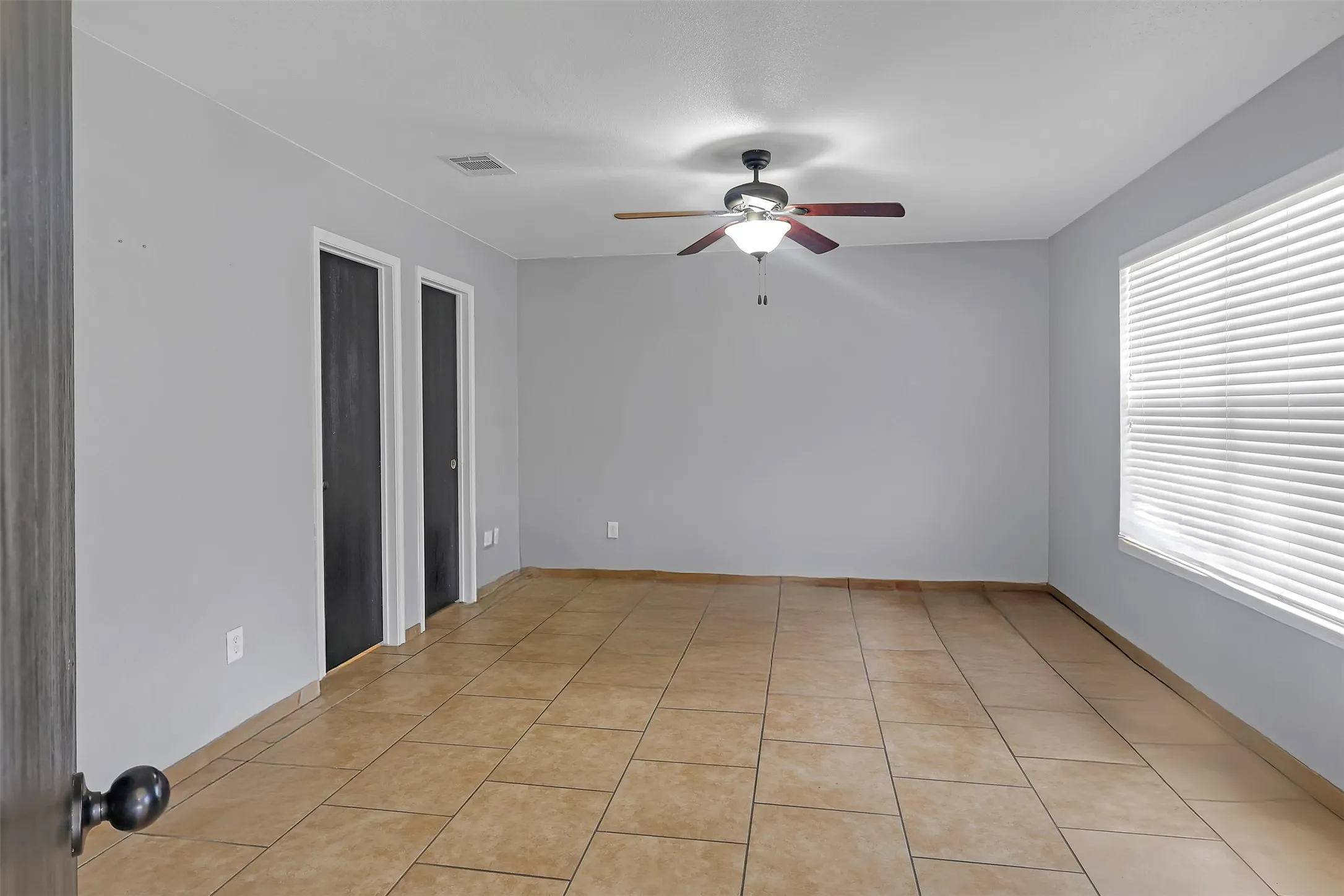 Spare room with light tile patterned floors and a ceiling fan