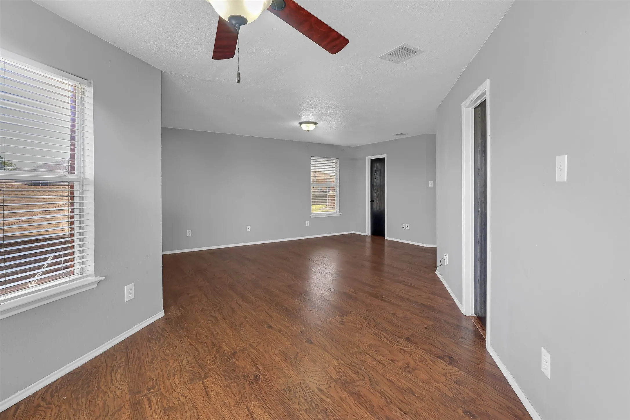 Spare room with dark wood-style flooring and a ceiling fan