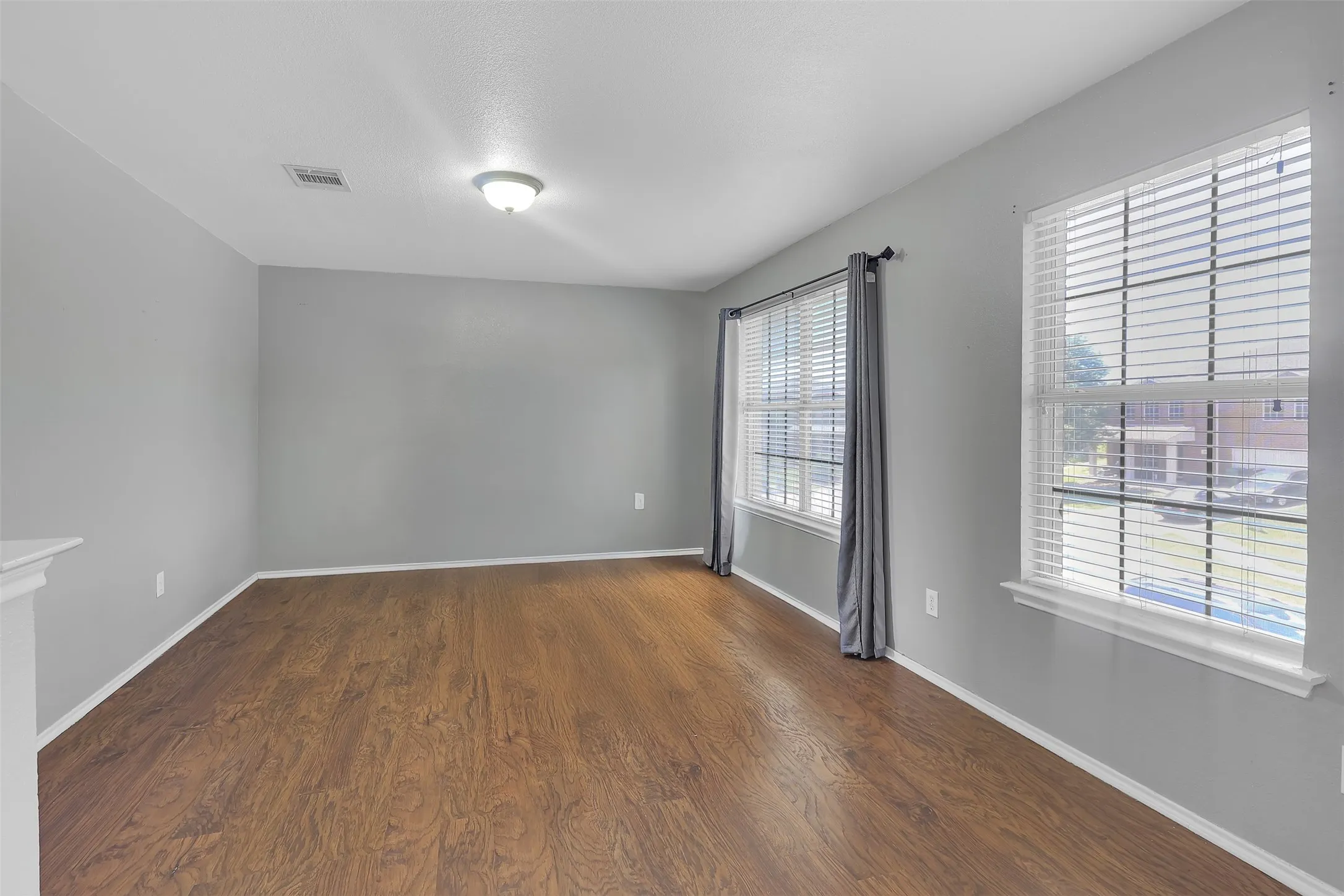 Unfurnished room with dark wood-type flooring and baseboards