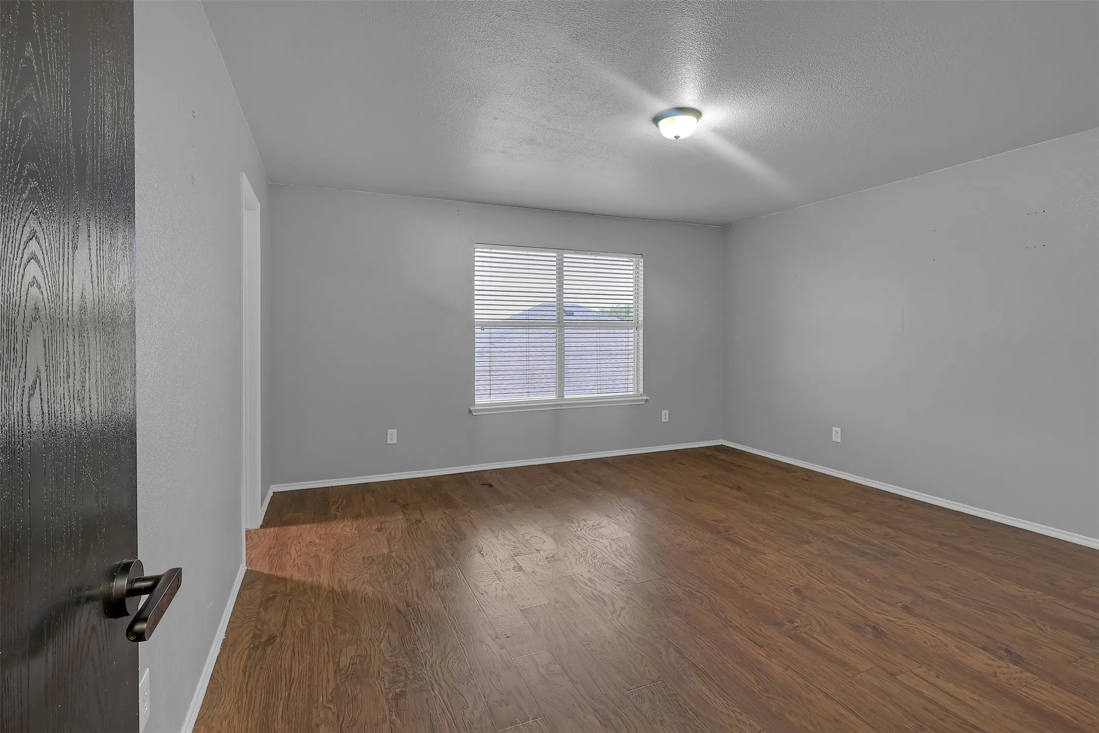 Unfurnished room with a textured ceiling and dark wood finished floors