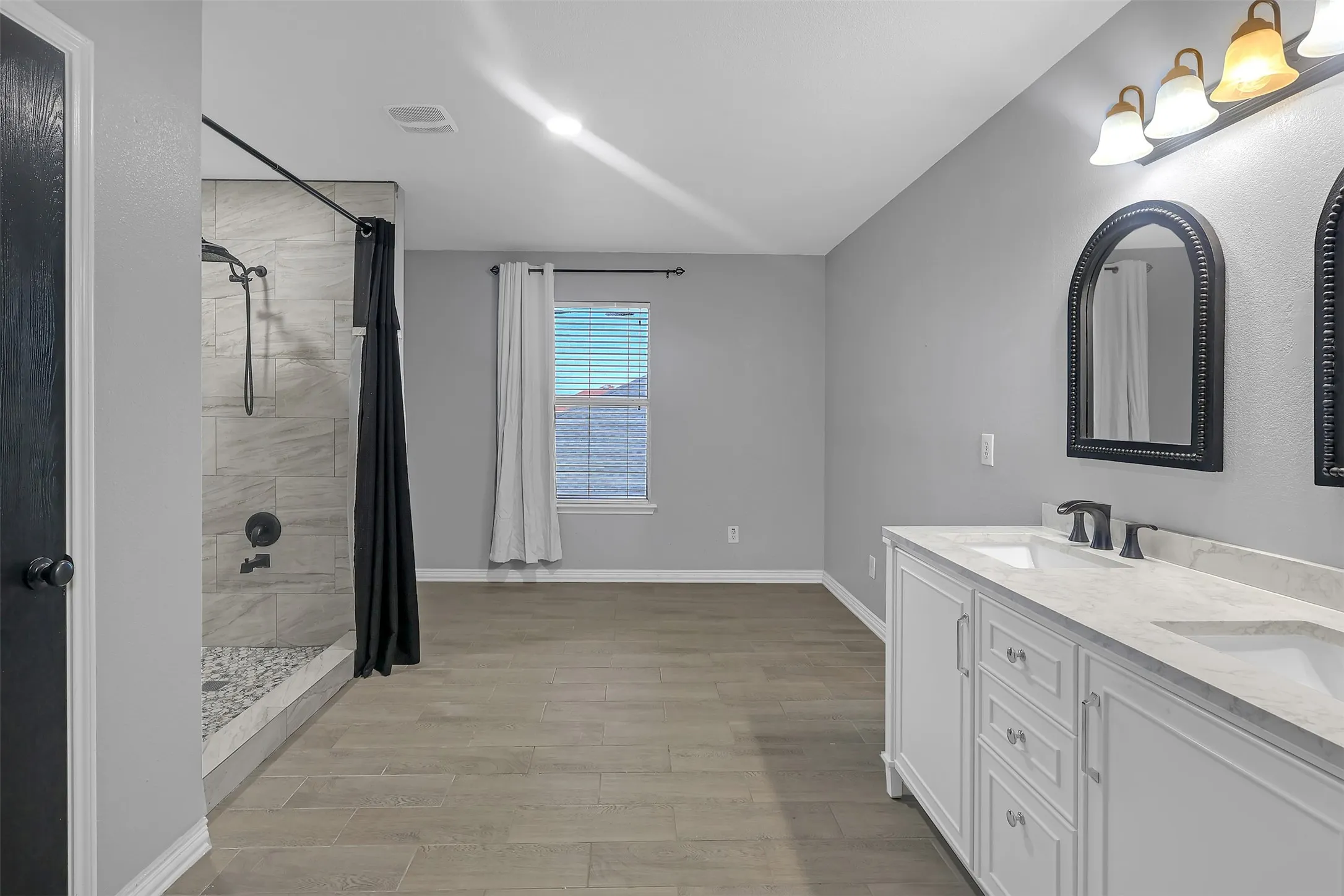 Full bathroom featuring a stall shower and light wood-style floors