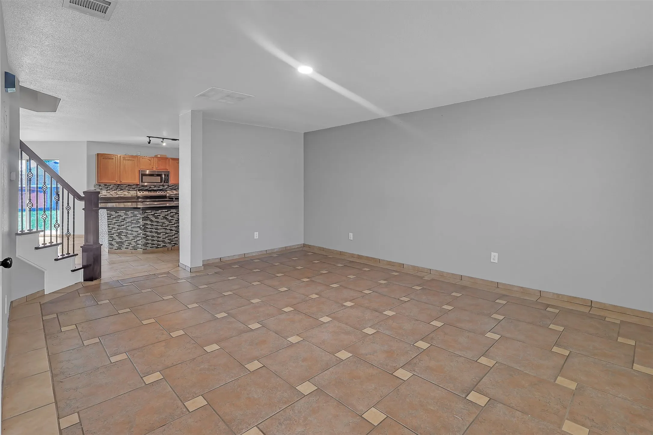 Spare room with stairway and baseboards