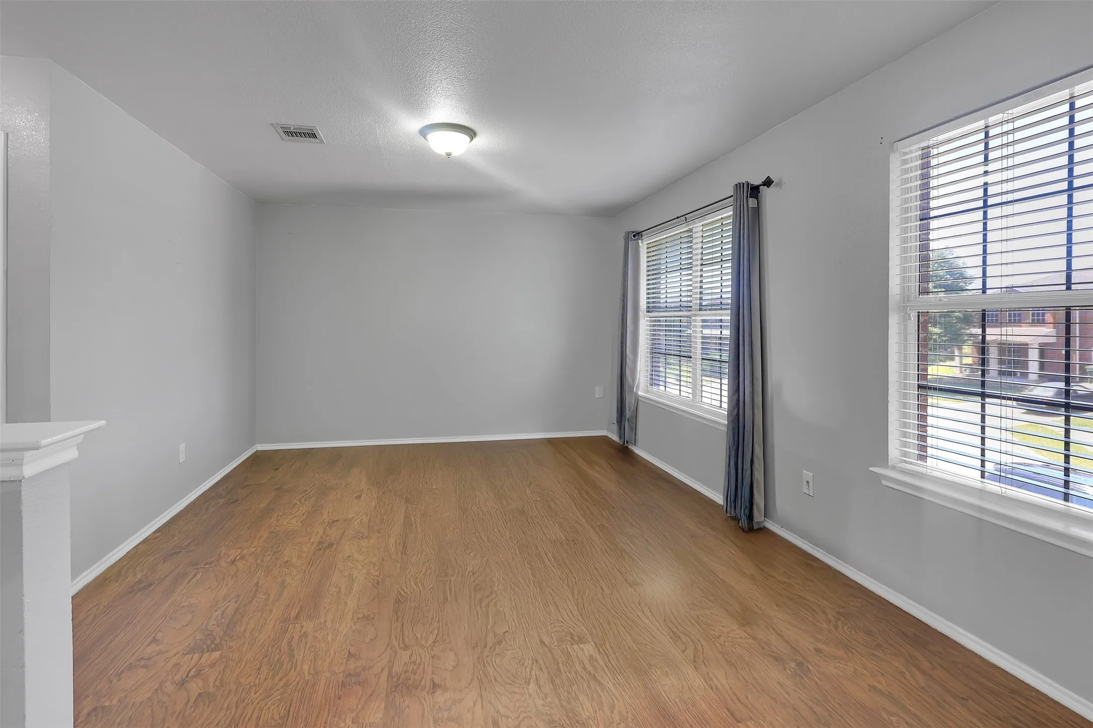Empty room with wood finished floors and a textured ceiling