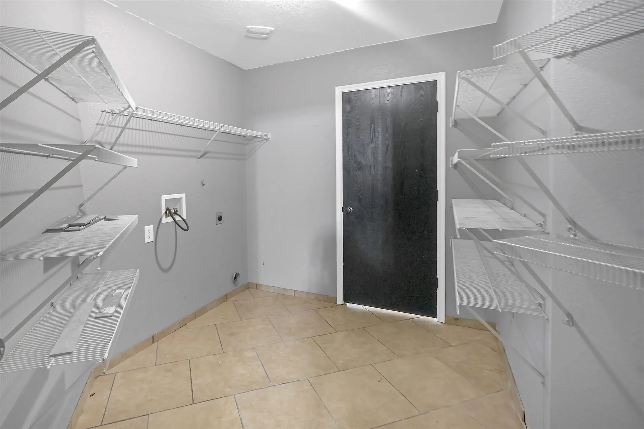Laundry room featuring washer hookup, hookup for an electric dryer, and light tile patterned floors
