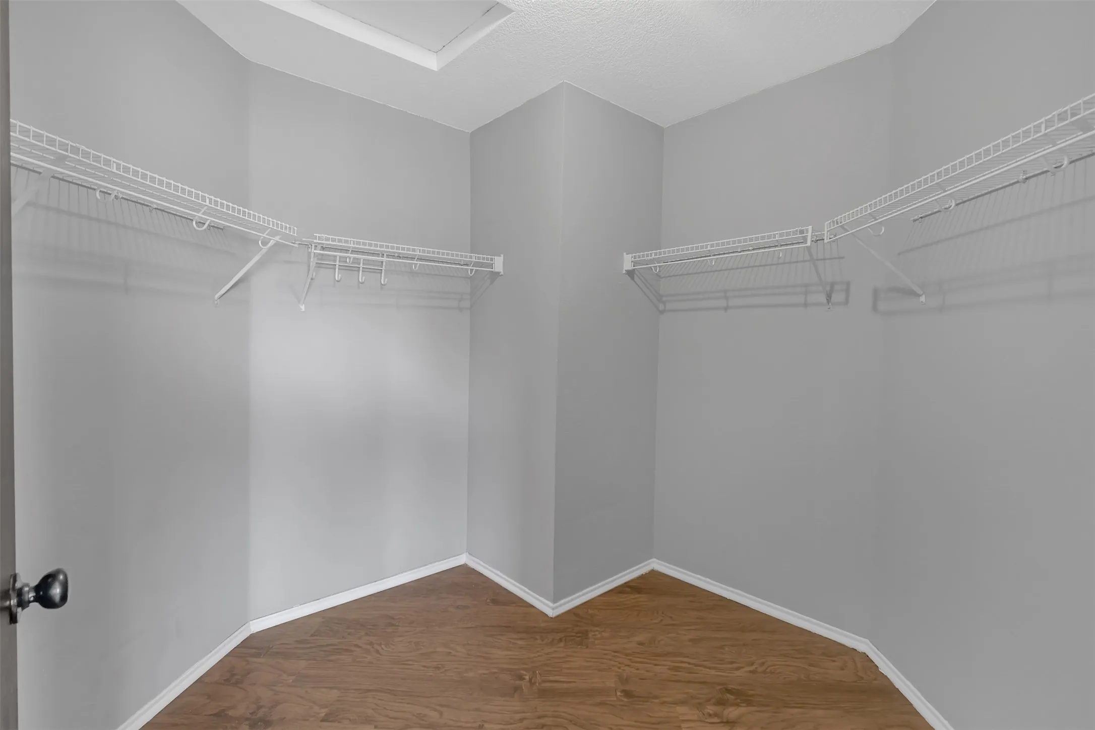 Walk in closet with dark wood-style flooring
