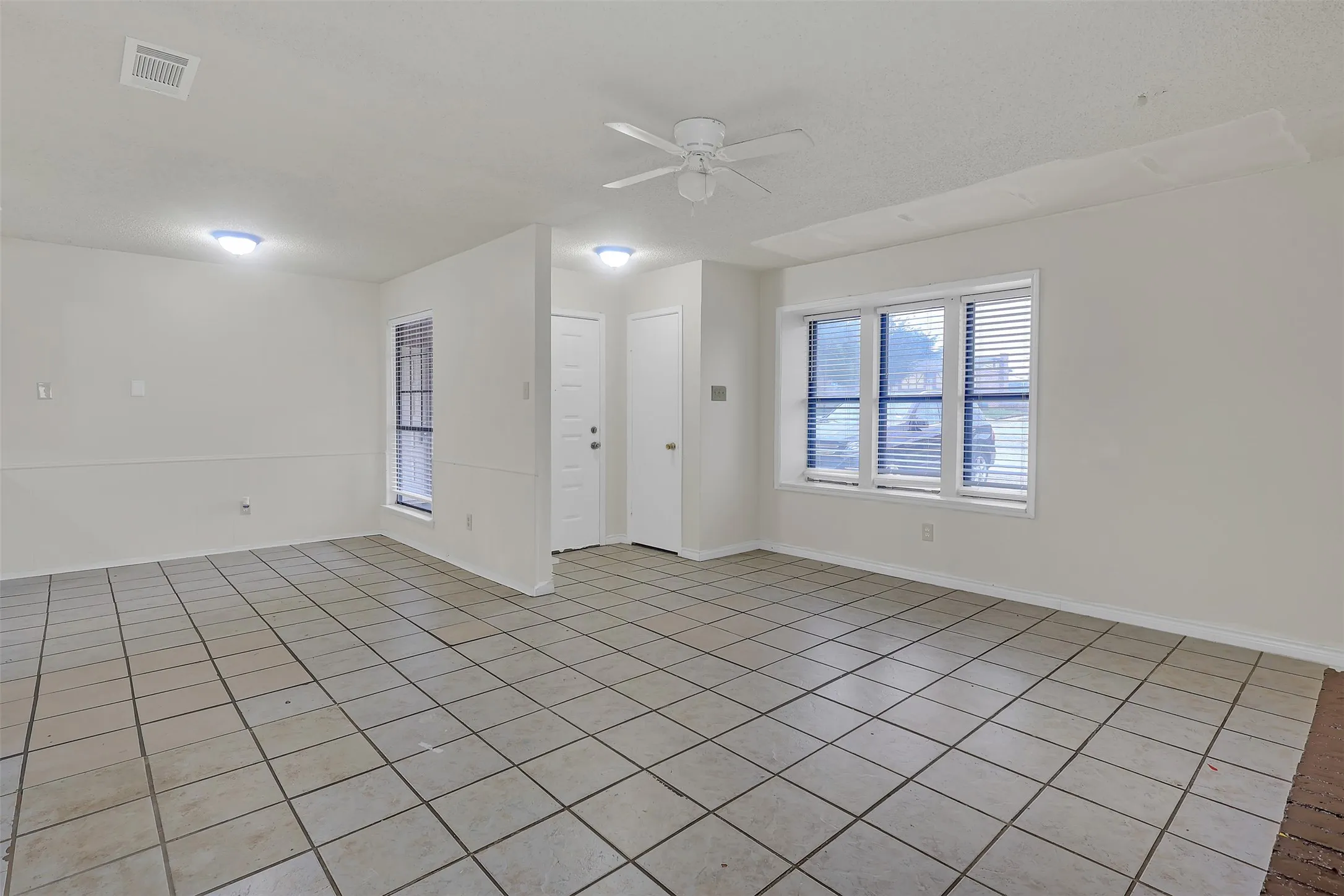 Spare room with a ceiling fan and light tile patterned floors