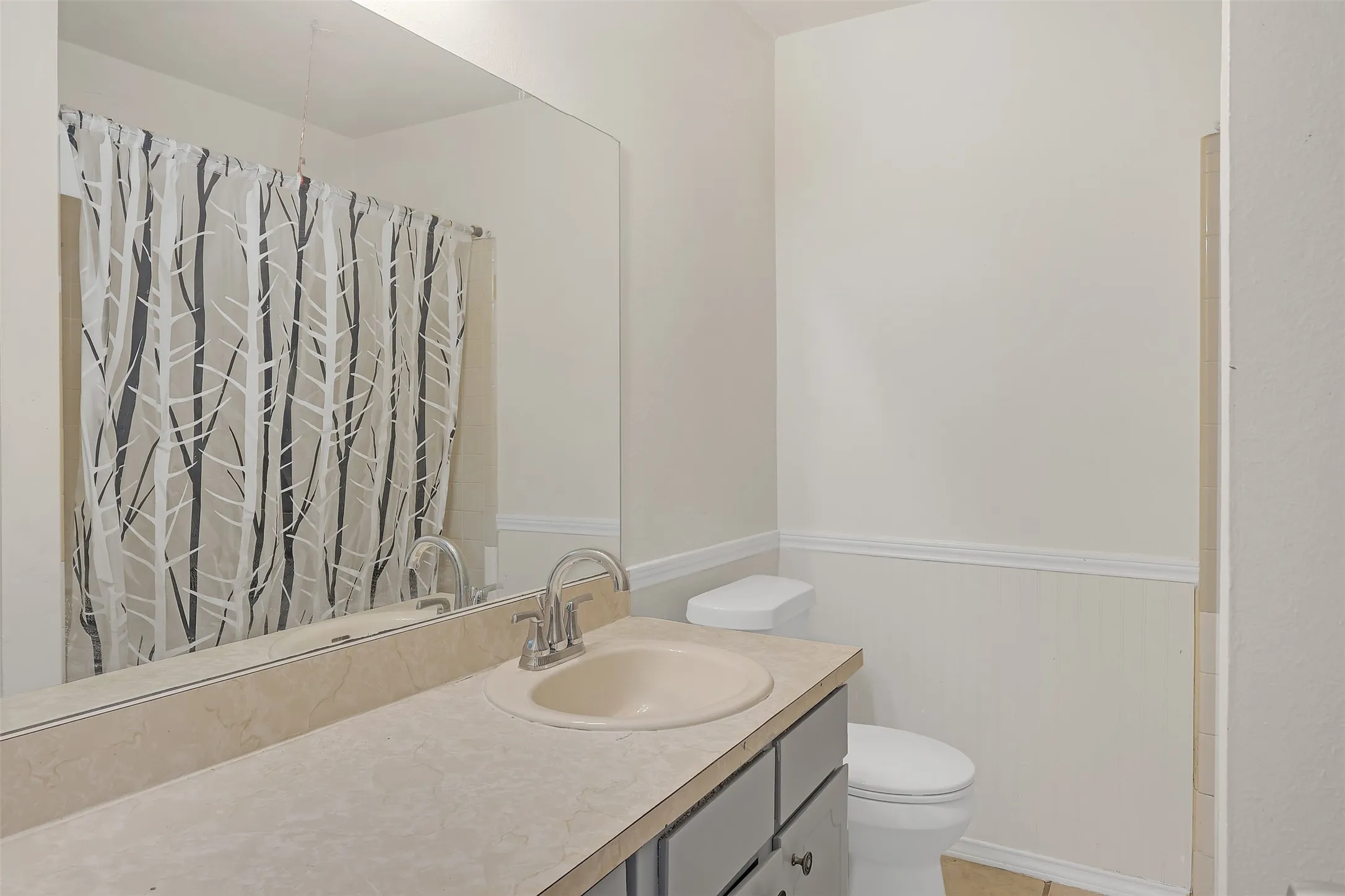 Full bath featuring vanity and wainscoting
