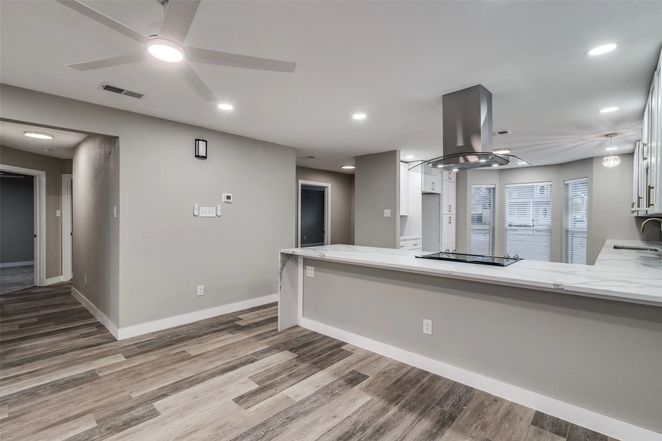 Open concept living area featuring wood-finish flooring, recessed lighting, and a modern ceiling fan