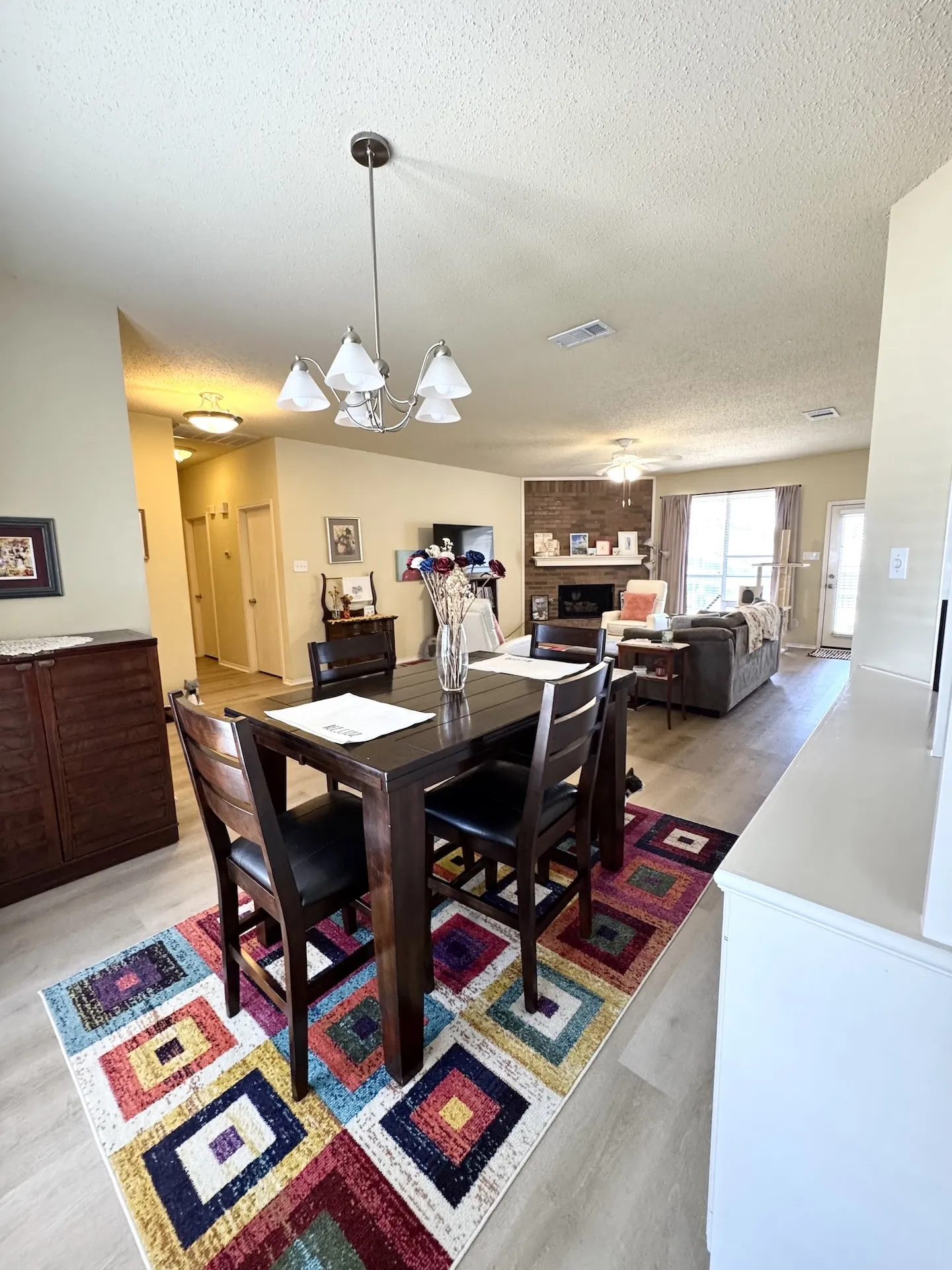 Hard-surface flooring throughout, featuring a five-light chandelier in the dining area